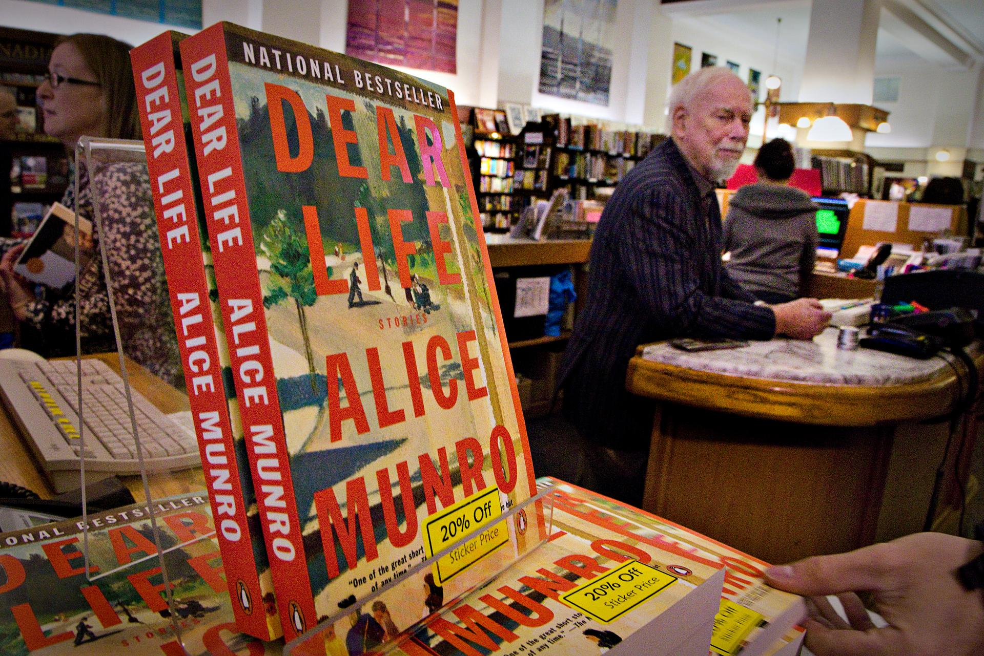 Canadian author Alice Munro's books sit on the bookshelf as her former husband Jim stands at the front counter at Munro's Bookstore in Victoria, British Columbia October 10, 2013.