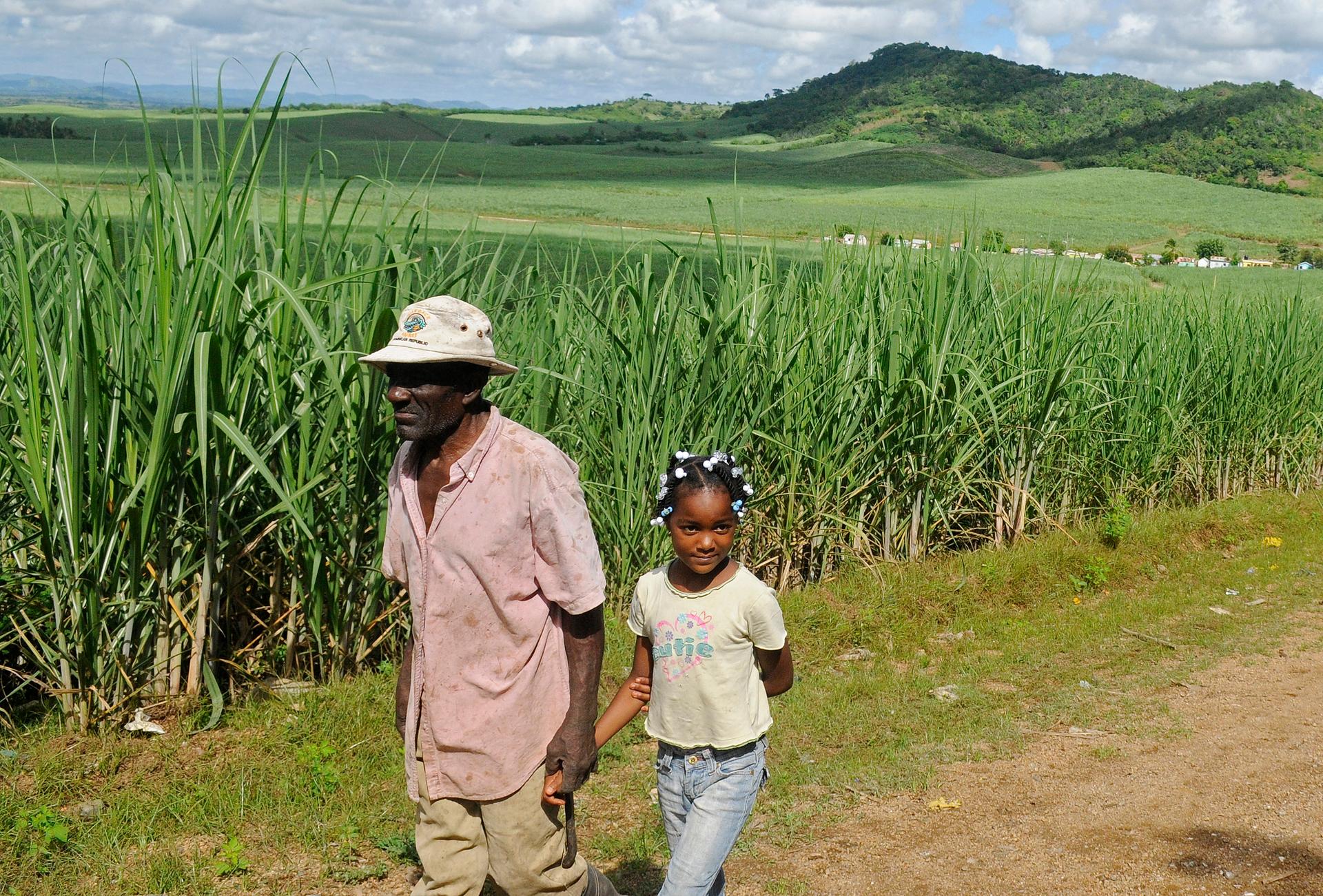 Leguisie Louis (L), a farmer, was born in Haiti but moved to the Dominican Republic in 1959. He's seen here walking with his granddaughter, Maxileidy. A  court ruling retroactively denies Dominican nationality to anyone born after 1929 who does not have a