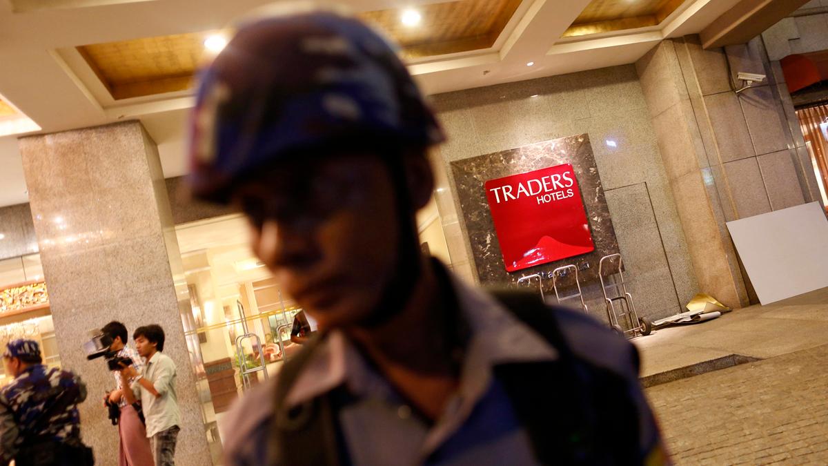 A police officer stands in front of Traders Hotel, where an explosion occurred, in central Yangon early October 15, 2013.