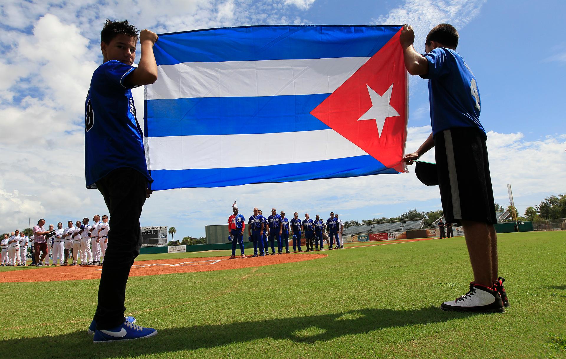 The Cuban flag is displayed during pre-game anthems at exhibition game between members of one of Cuba's most famous baseball teams, Industriale, in Ft. Lauderdale, Florida.