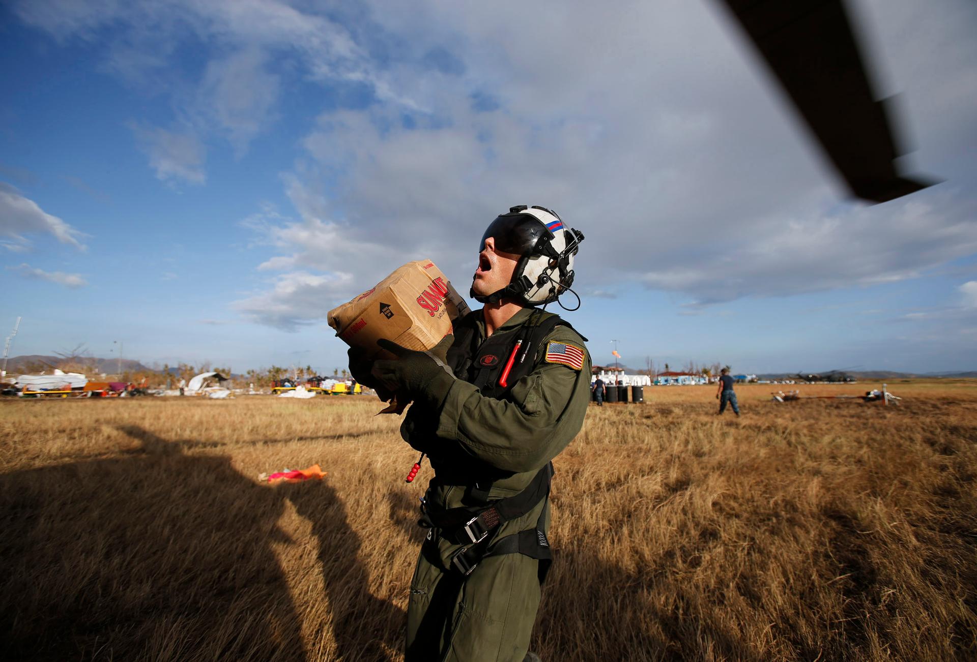 A US Marine takes a gasp of air while loading humanitarian goods into helicopter as part of relief efforts in the Philippines following Super Typhoon Haiyan in 2013.