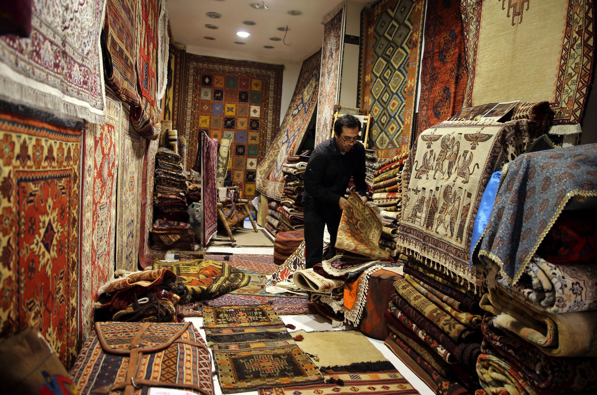 A seller arranges Iranian carpets at his shop in Dubai old market November 24, 2013.