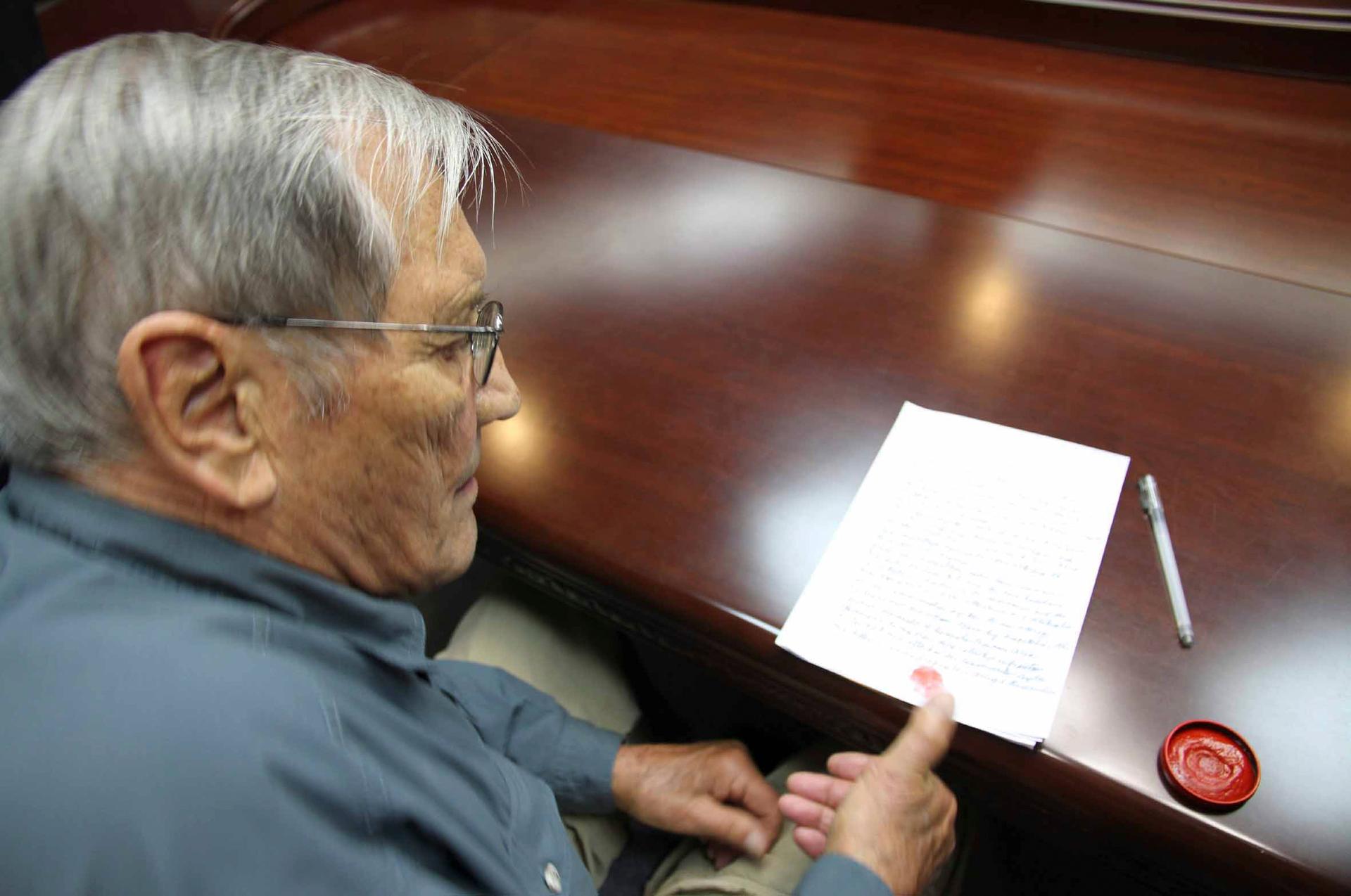 U.S. citizen Merrill E. Newman puts his thumbprint on a piece of paper, after being taken into custody by North Korea, at an undisclosed location in this undated photo released by North Korea's Korean Central News Agency (KCNA) in Pyongyang on November 30