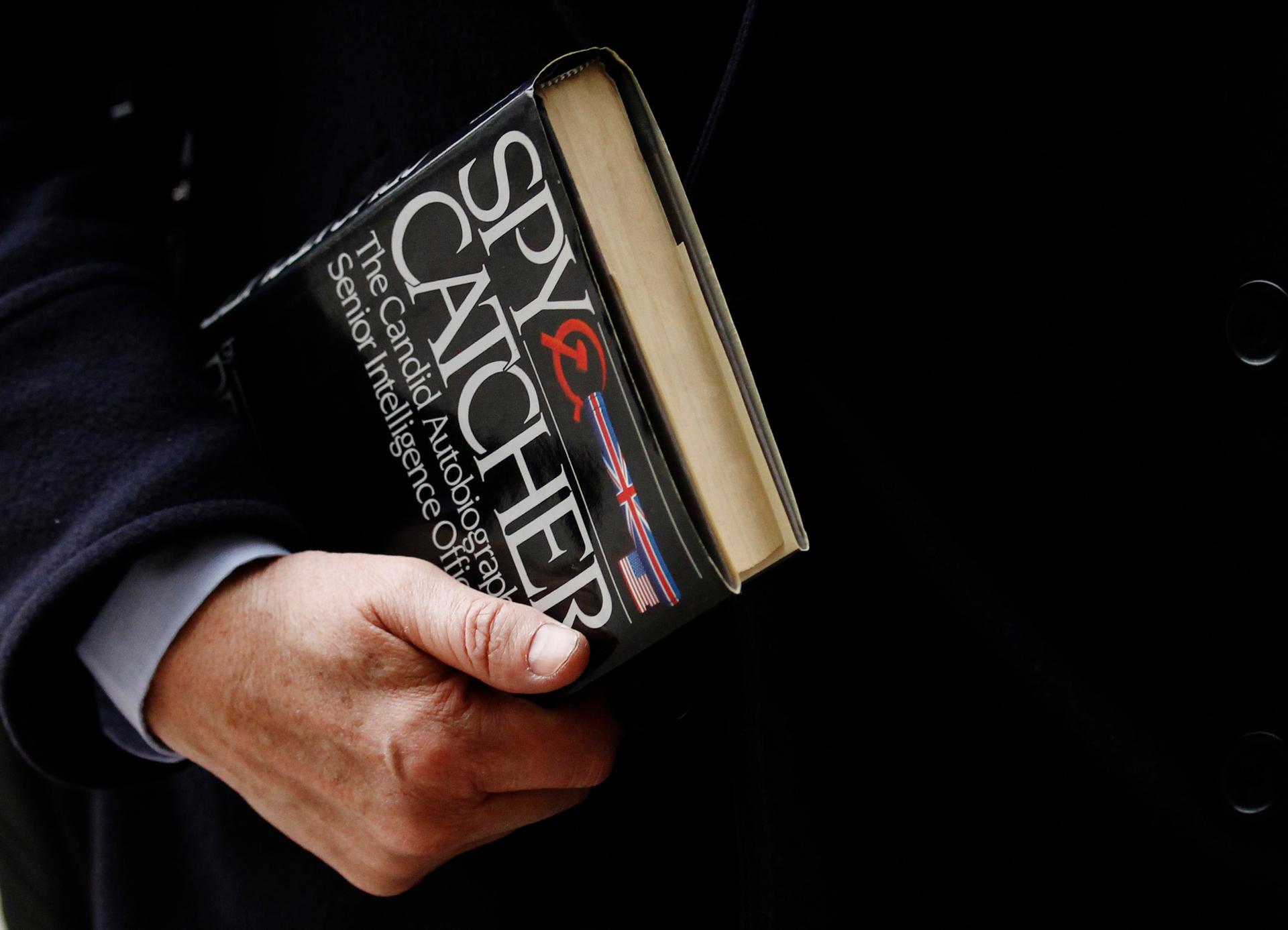 Guardian Editor Alan Rusbridger carries a copy of the book Spy Catcher as he arrives at Parliament to face questions over his publication of intelligence files from Edward Snowden.