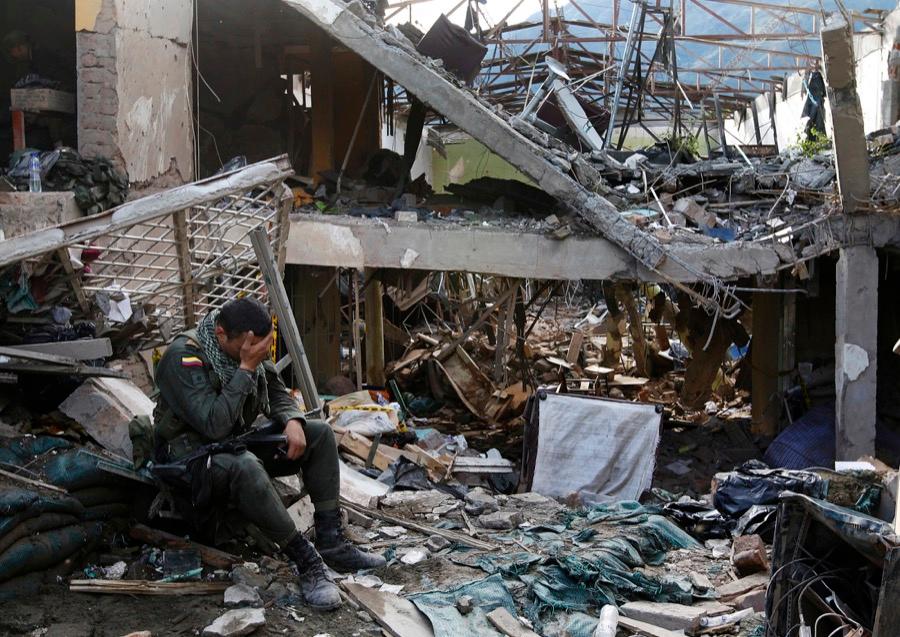 A Colombian police officer sits in the ruins of a police station destroyed by a deadly bomb attack in the municipality of Inza in Cauca province in December 2013, which was blamed on the FARC.