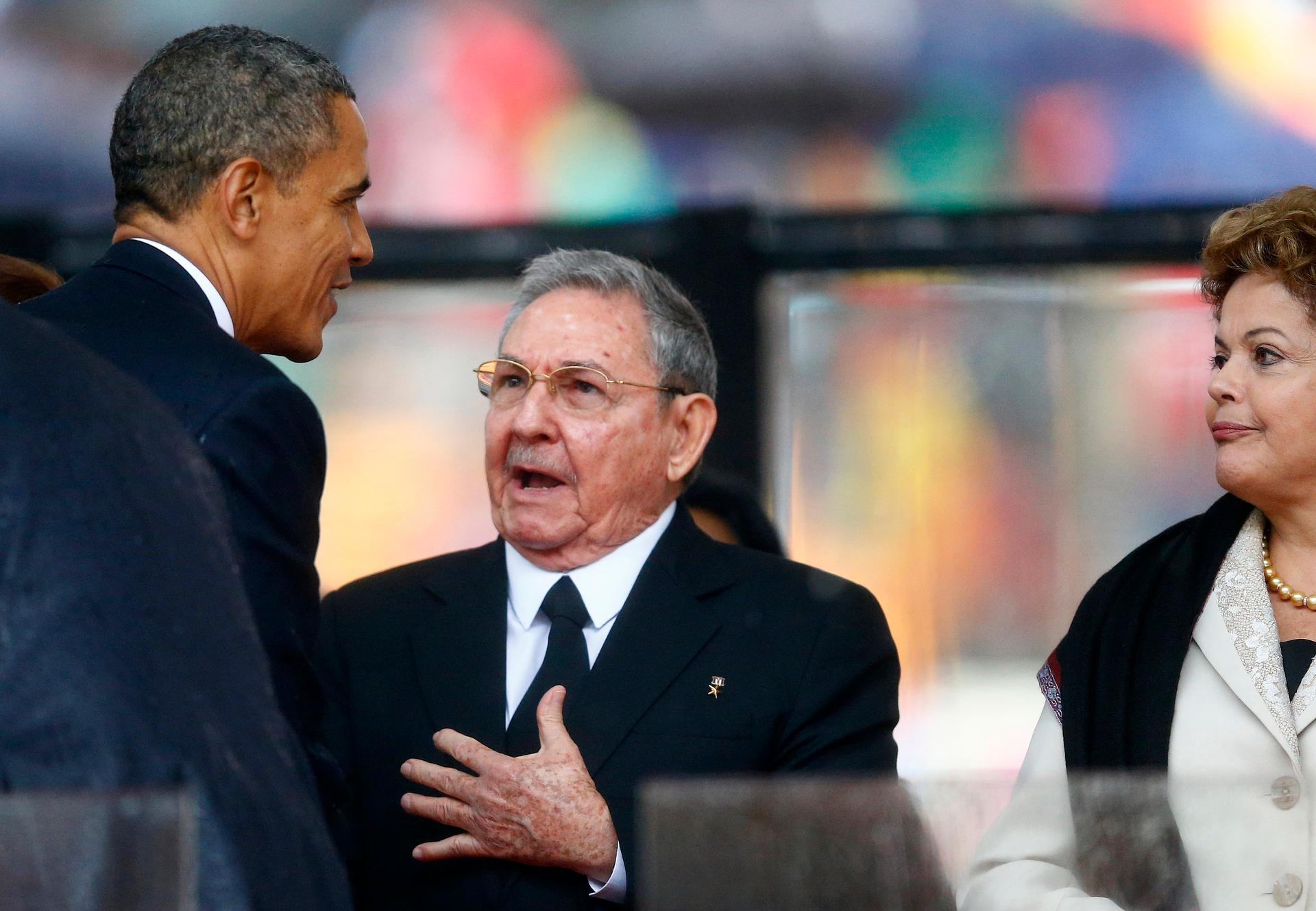 U.S. President Barack Obama greets Cuban President Raul Castro before giving his speech, as Brazil's President Dilma Rousseff looks on, at the memorial service for late South African President Nelson Mandela 