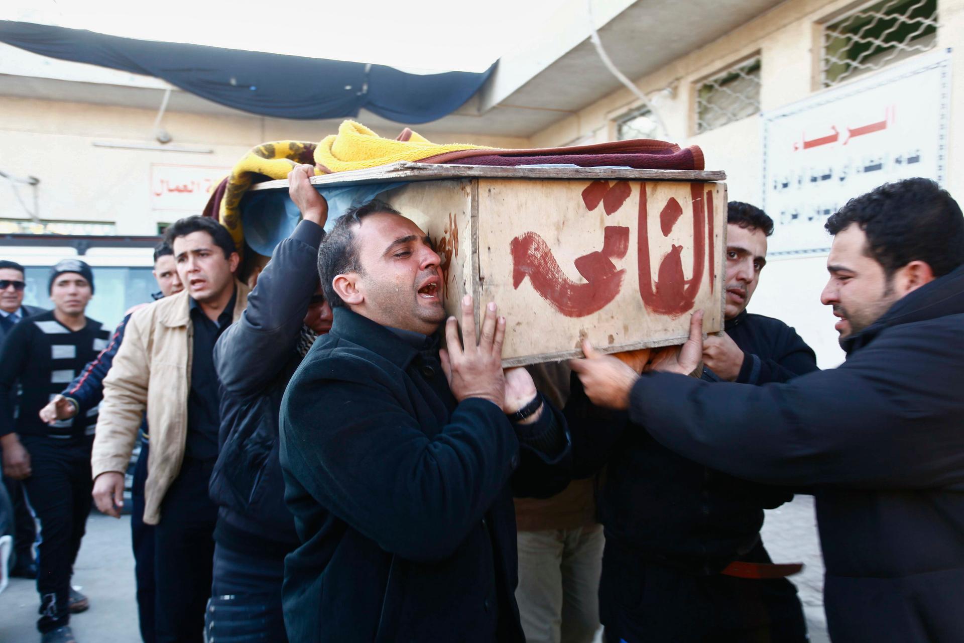 Mourners carry the coffin of their relative