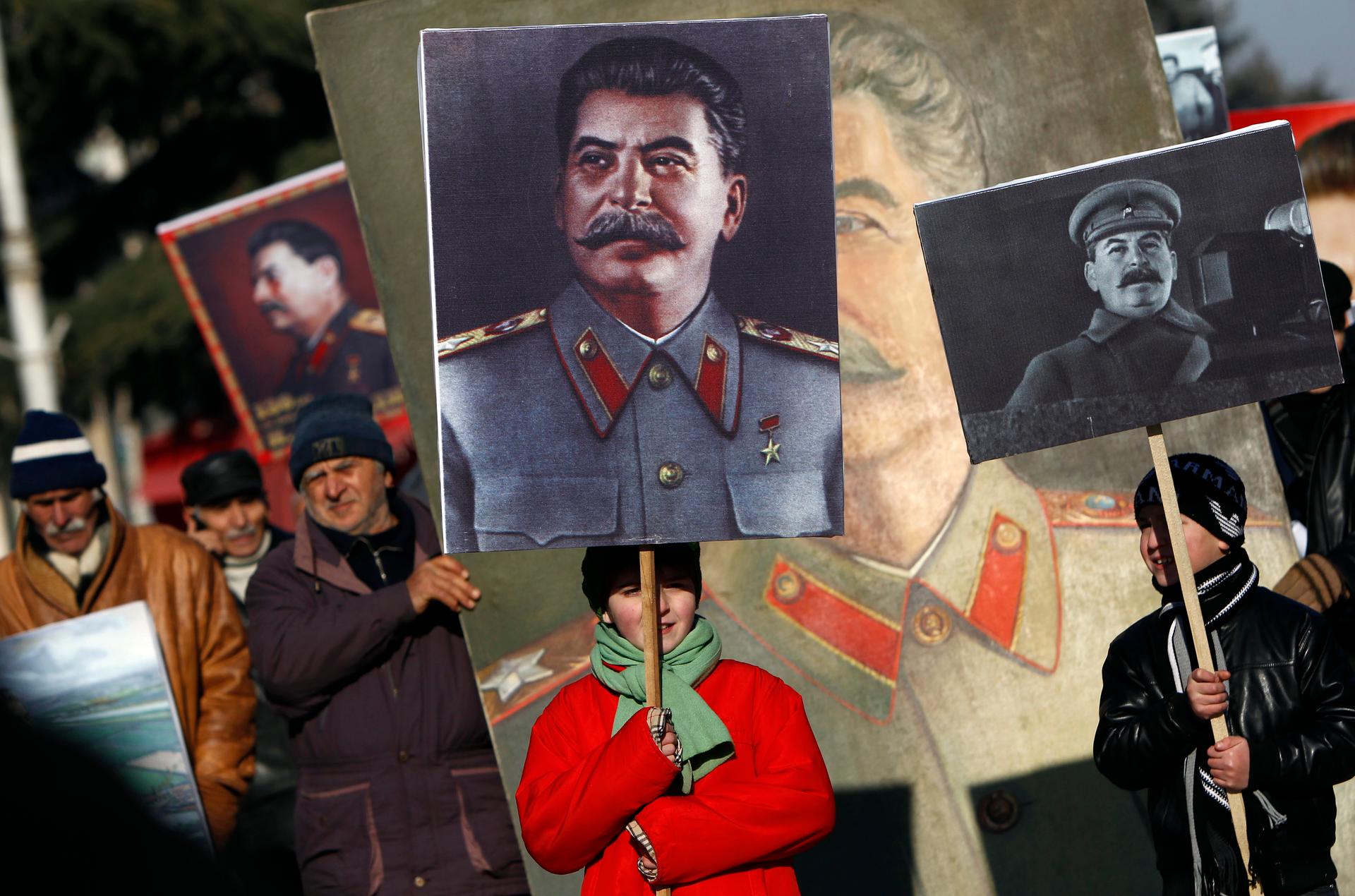 People carry portraits of late Soviet dictator Josef Stalin as they attend a gathering marking the 130th anniversary of his birthday