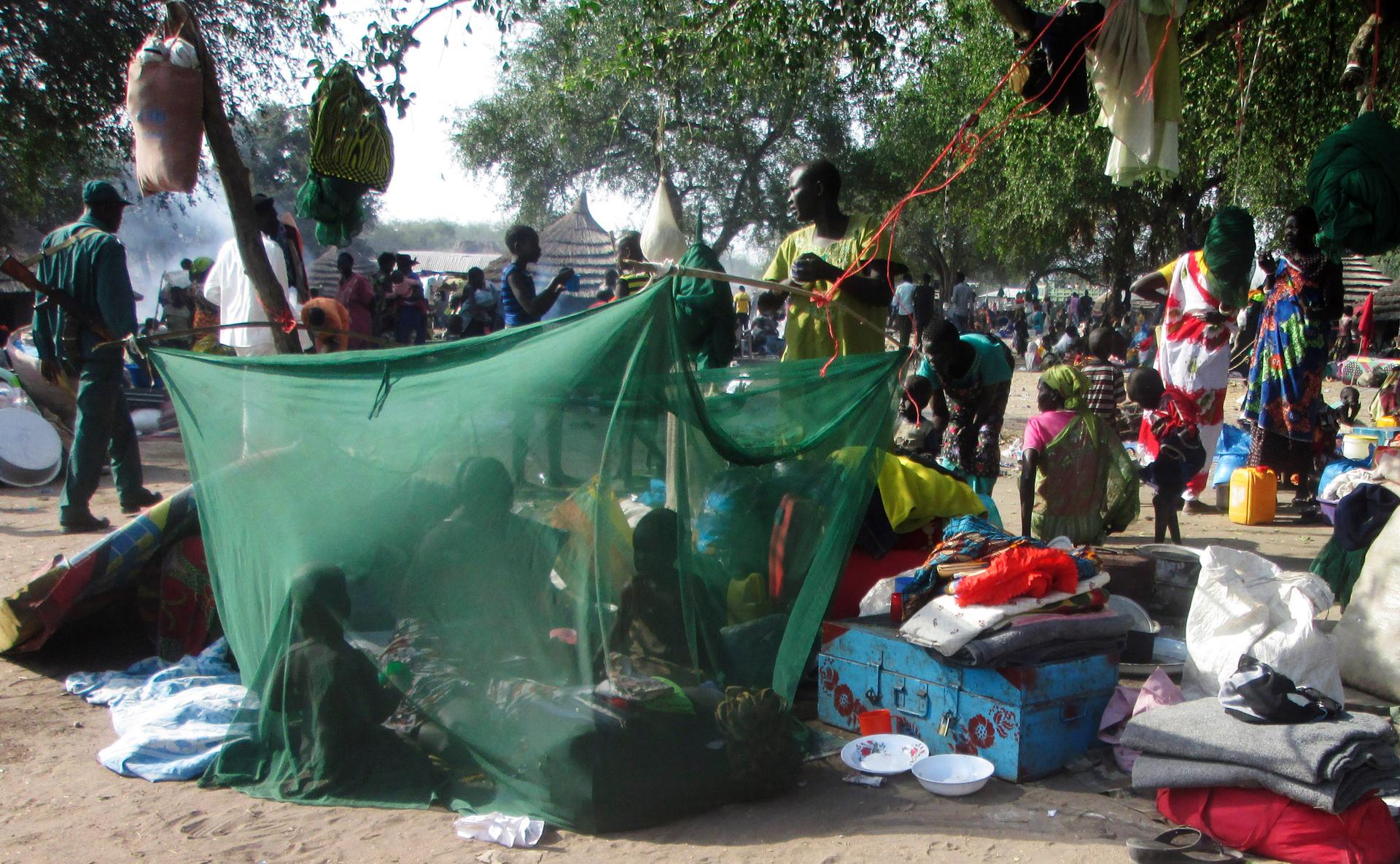 Displaced people gather inside a mosquito net tent as they flee from fighting between the South Sudanese army and rebels in Bor.