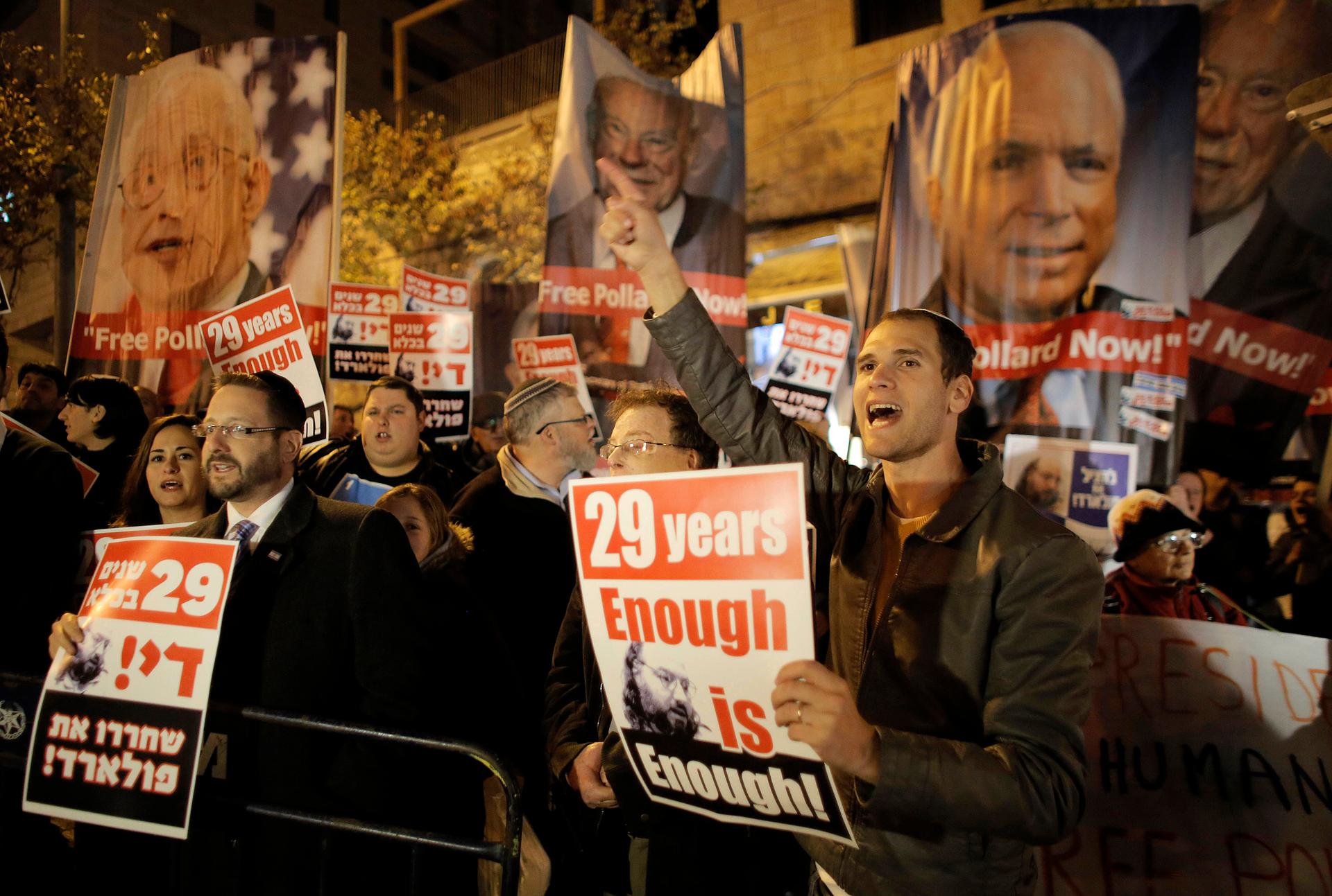 Israelis hold placards during a protest calling for the release of Jonathan Pollard from U.S. prison, outside U.S. Secretary of State John Kerry's hotel in Jerusalem on January 2, 2014.