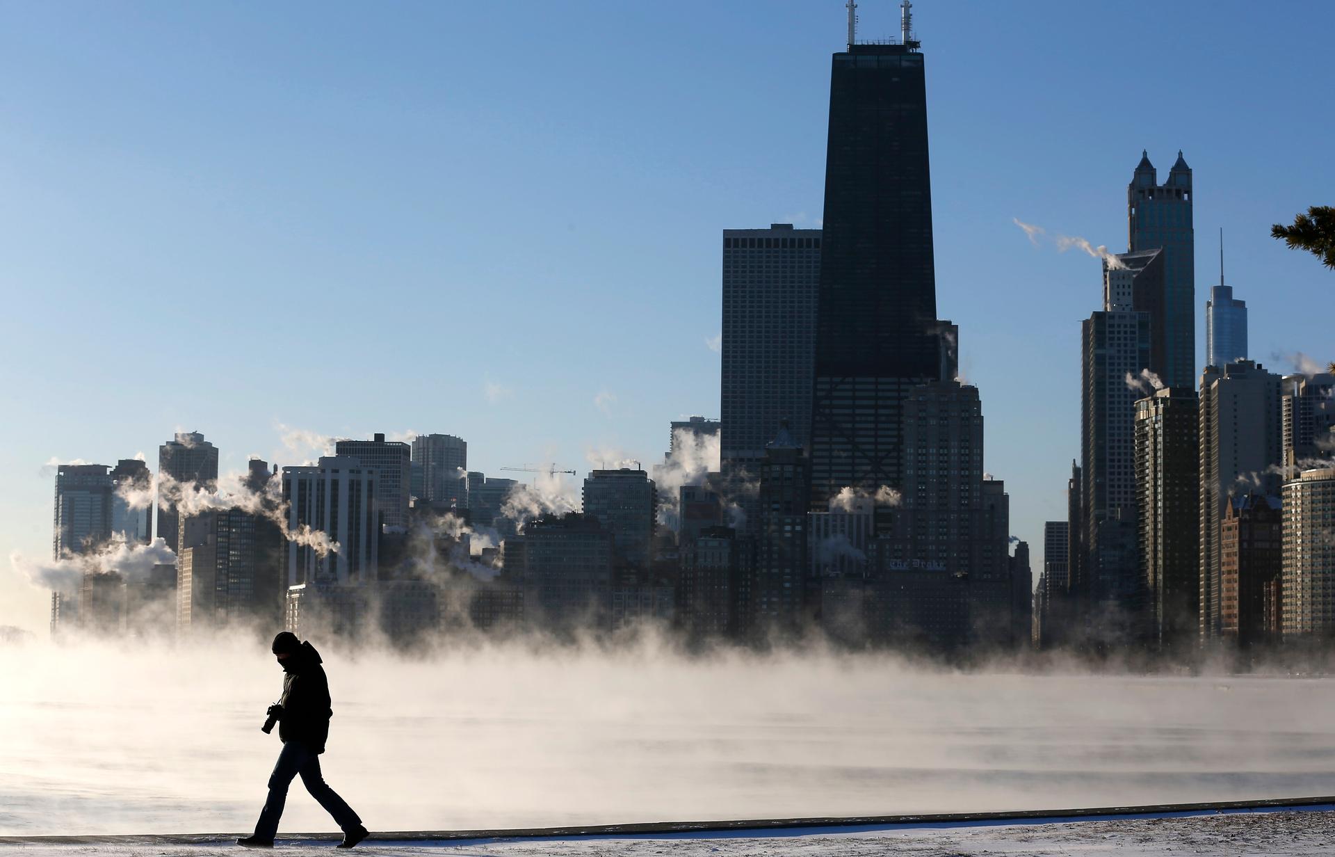 A man is silhouetted against condensation rising off of Lake Michigan in Chicago on January 6, 2014. Chicago was experiencing historic cold this week.