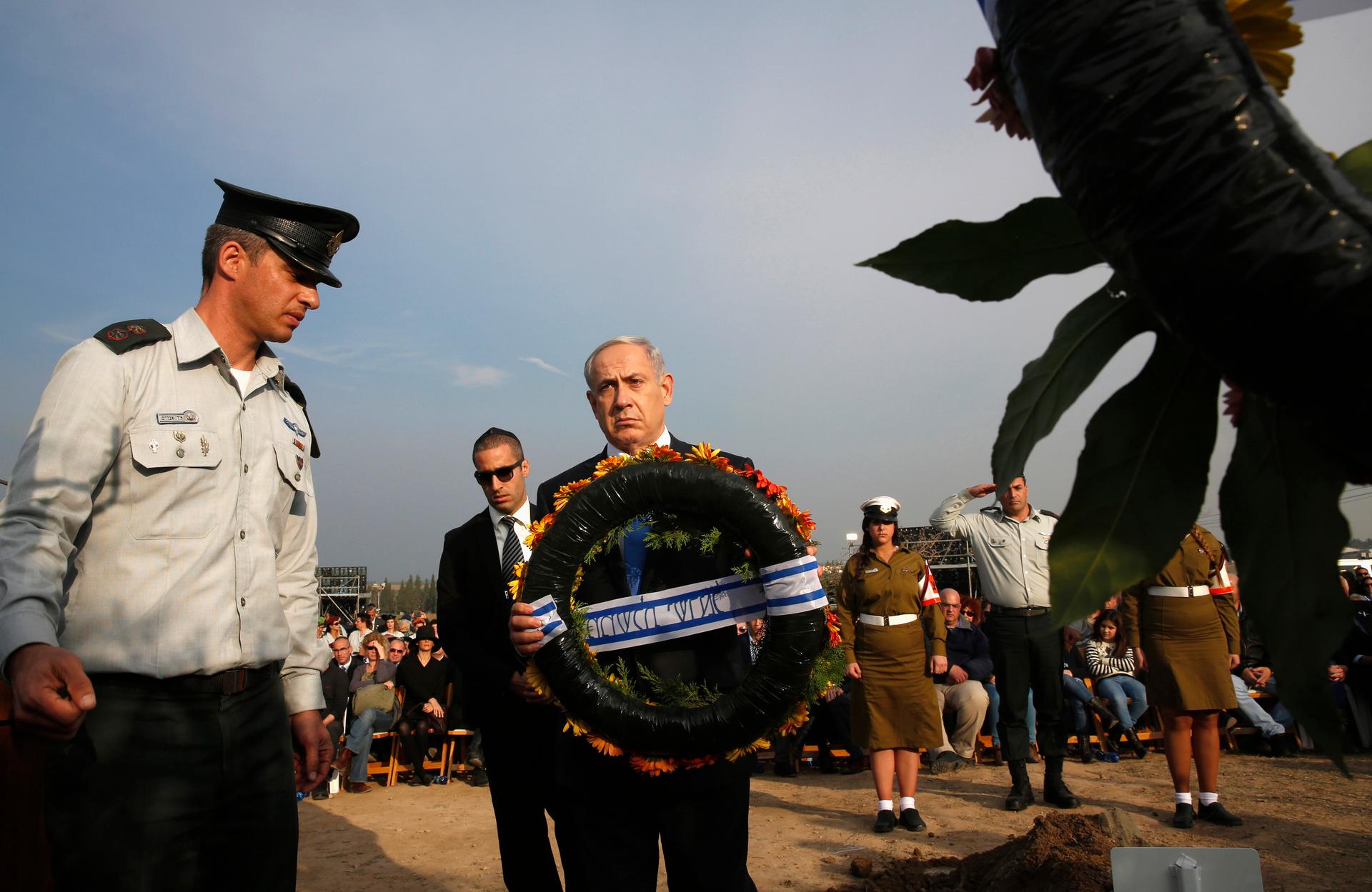 Israeli Prime Minister Benjamin Netanyahu lays a wreath during the funeral service for Ariel Sharon near Sycamore Farm, Sharon's residence in southern Israel, on January 13, 2014. 