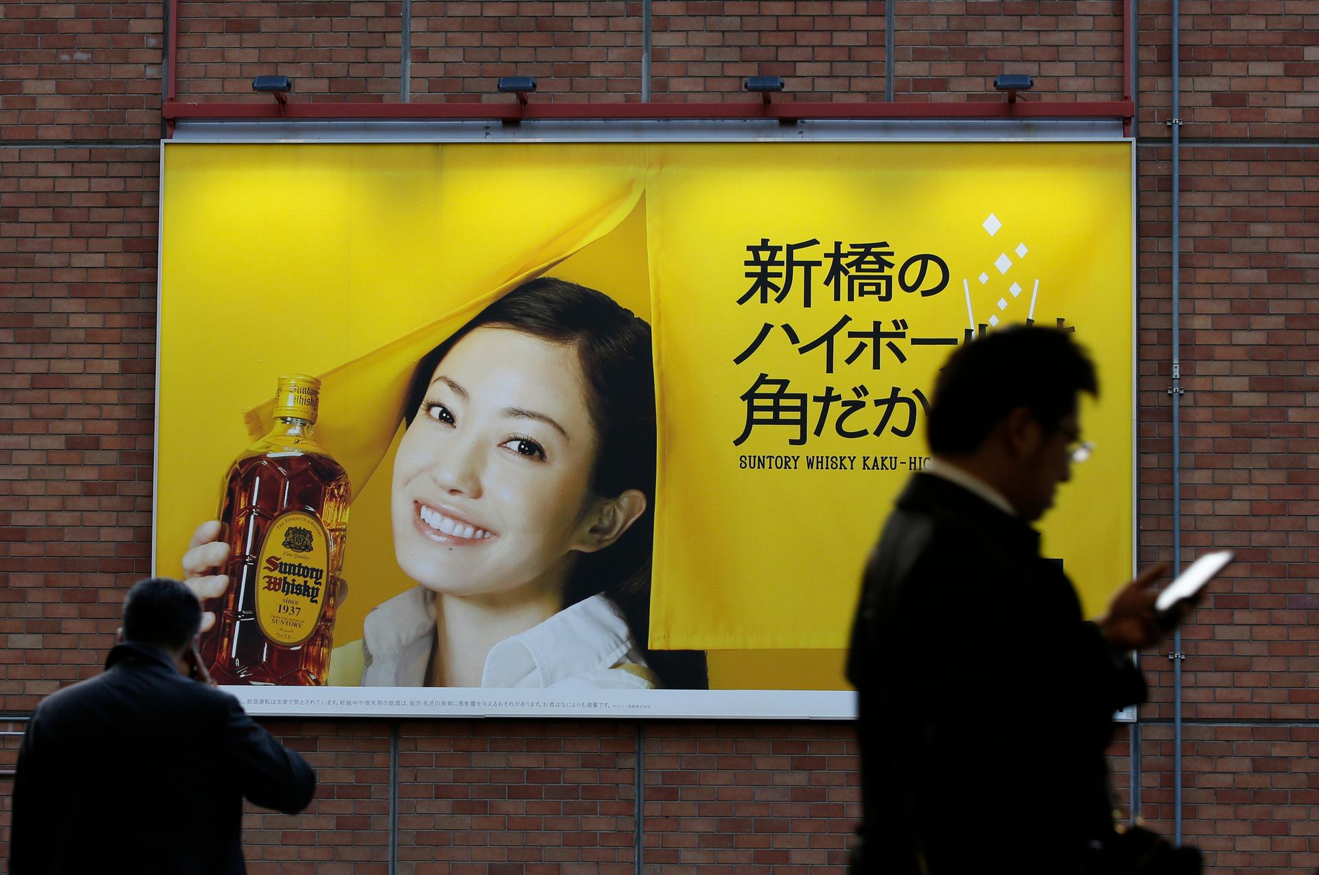 An advertisement for Suntory Holding's Kakubin whisky is displayed at a station in Tokyo on January 14, 2014.