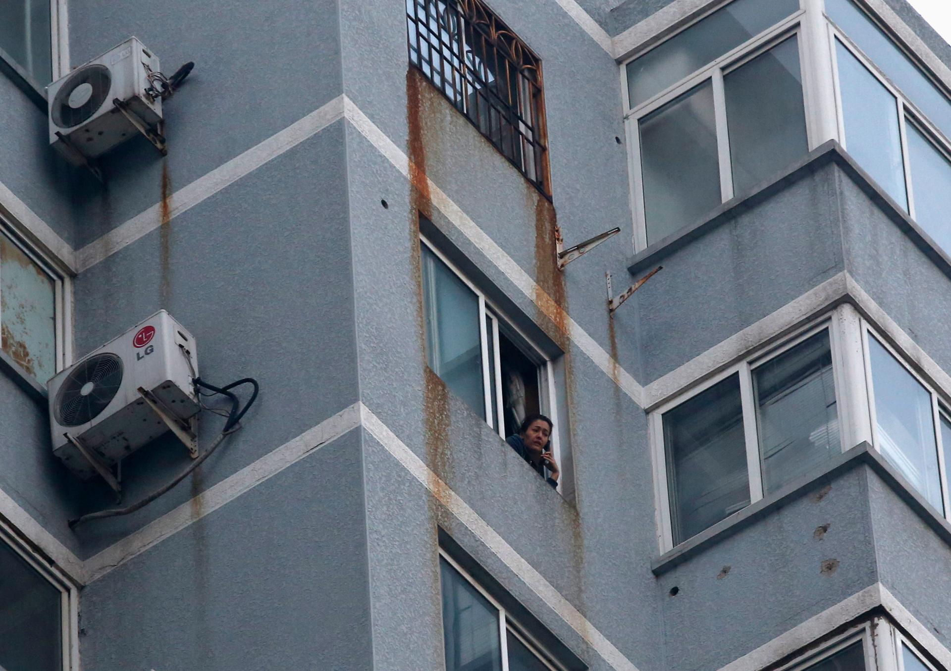 Guzailai Nu'er, the wife of Ilham Tohti, looks out the window of her house in Beijing as she does an interview over the phone with Reuters on January 17, 2014. Nu'er has been prevented from leaving by Chinese police. 