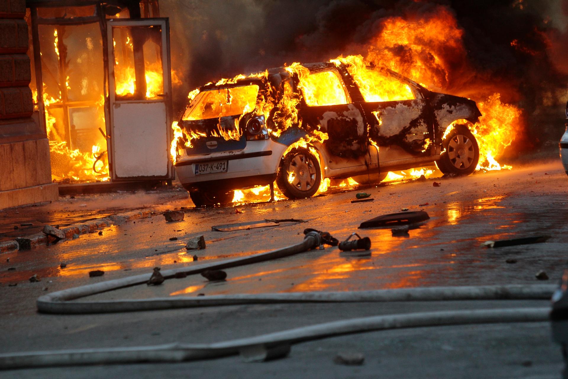 A car burns as anti-government protesters clash with police in Sarajevo. 