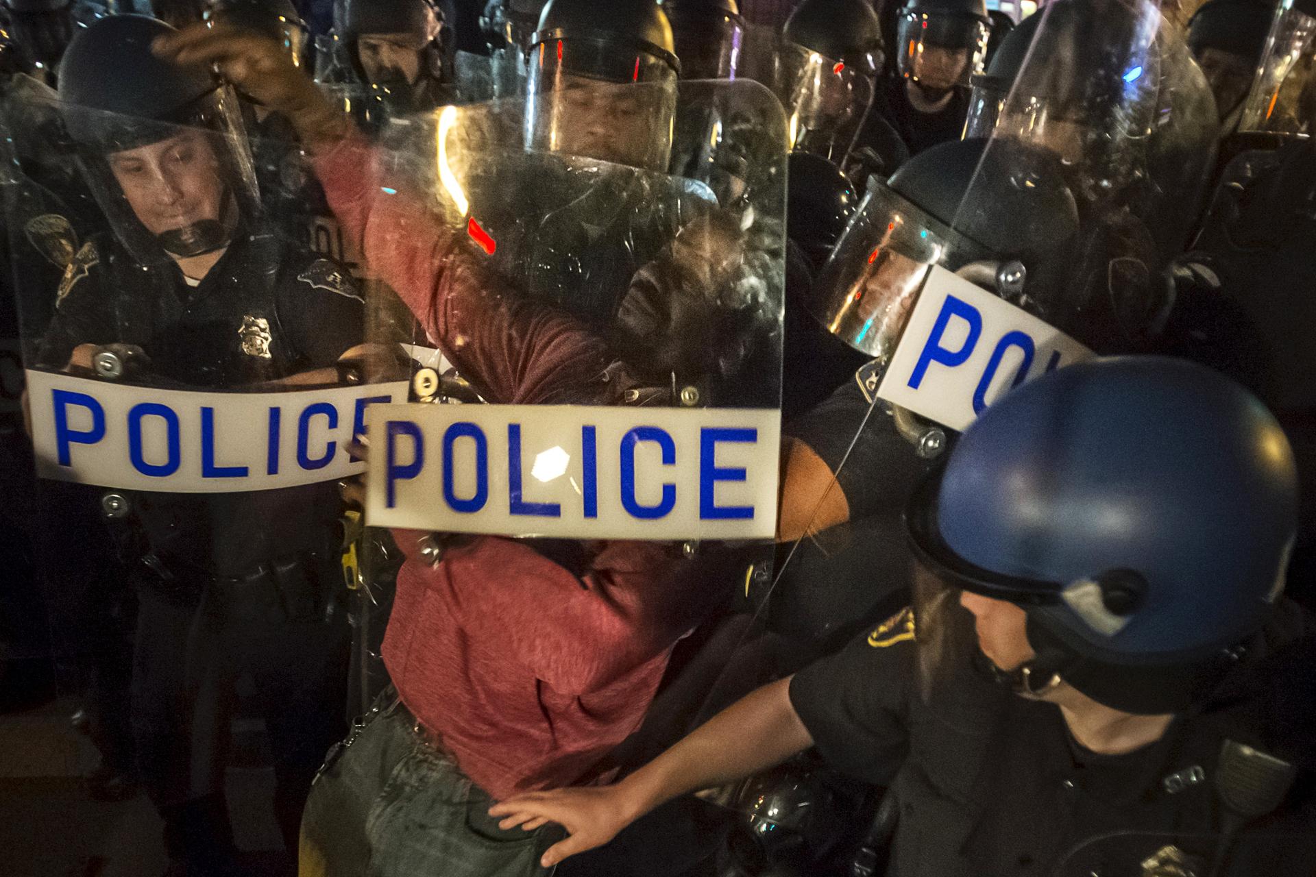 A man, protesting the death of Freddie Gray, is detained by police after defying a curfew in Baltimore, Maryland April 30, 2015.