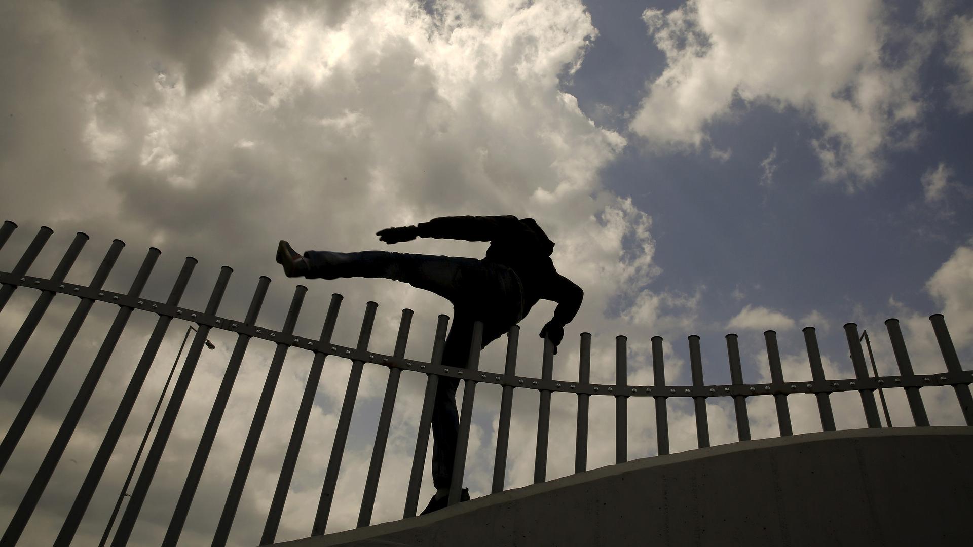 An African immigrant jumps over a fence into a ferry terminal in the western Greek town of Patras on April 28, 2015.