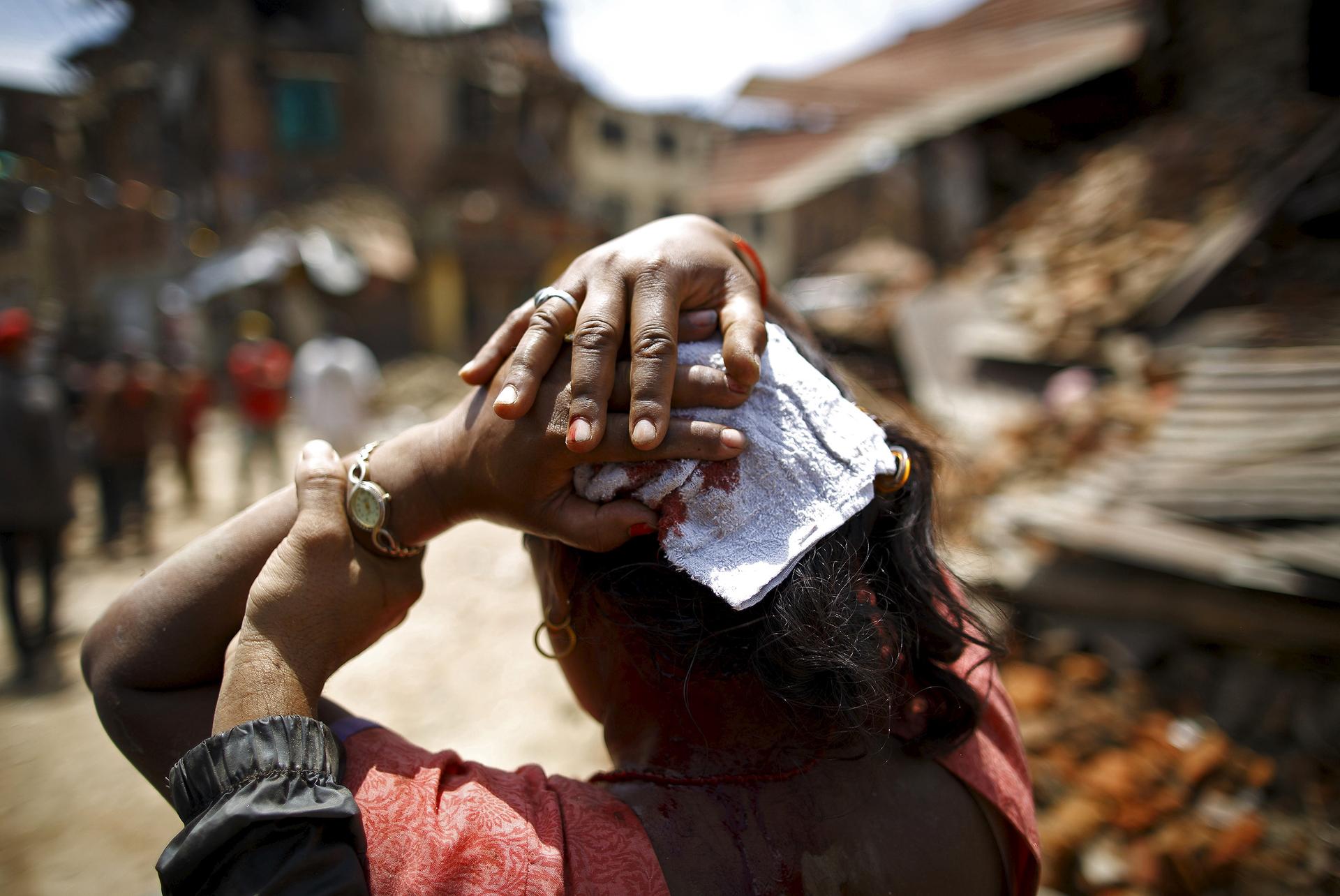 An injured woman walks toward a hospital soon after an earthquake struck Sankhu, Nepal, on May 12, 2015. The 7.3-magnitude quake killed more than two dozen people in Nepal and neighboring states.