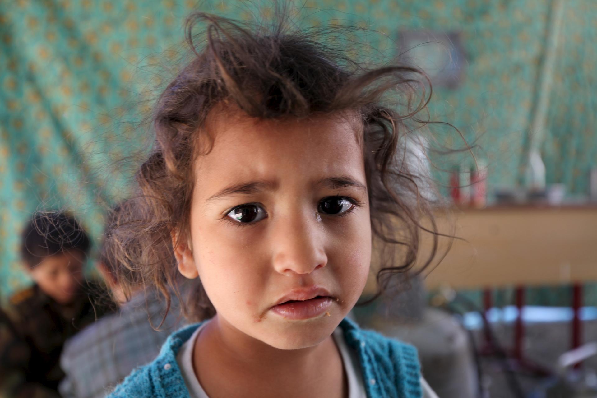An internally displaced girl waits for her turn to receive food at a school in Sanaa May 17, 2015. Residents were forced to leave their homes in the nearby province of Saada amidst Saudi-led air strikes.