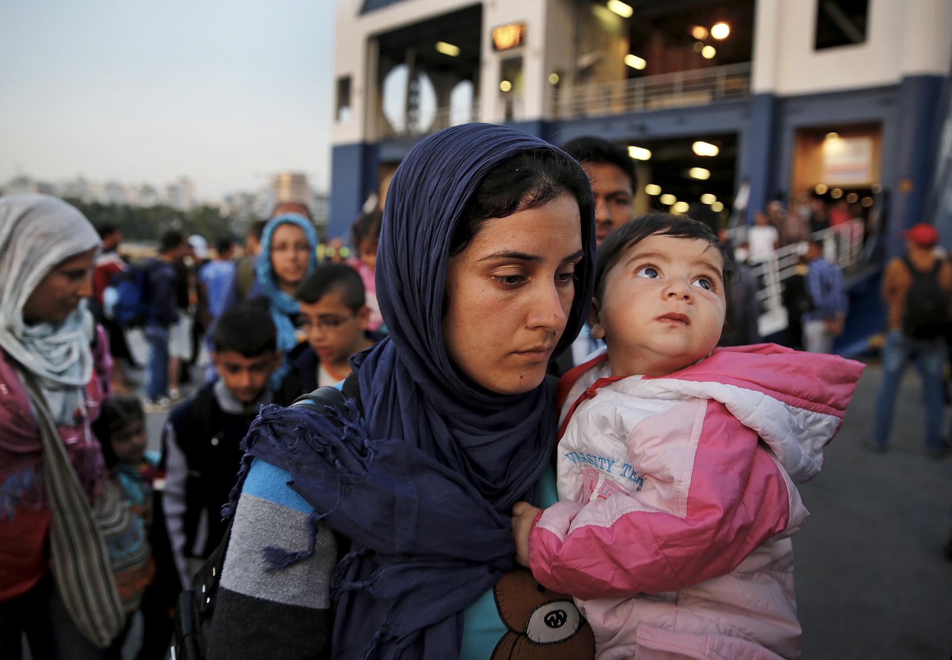 Syrian refugees disembarked from a Greek ferry near Athens on June 14, 2015. Over 1,800 predominantly Syrian refugees and other immigrants who crossed the sea from the Turkish coast to the Greek island of Lesbos were ferried to Athens after the Greek auth