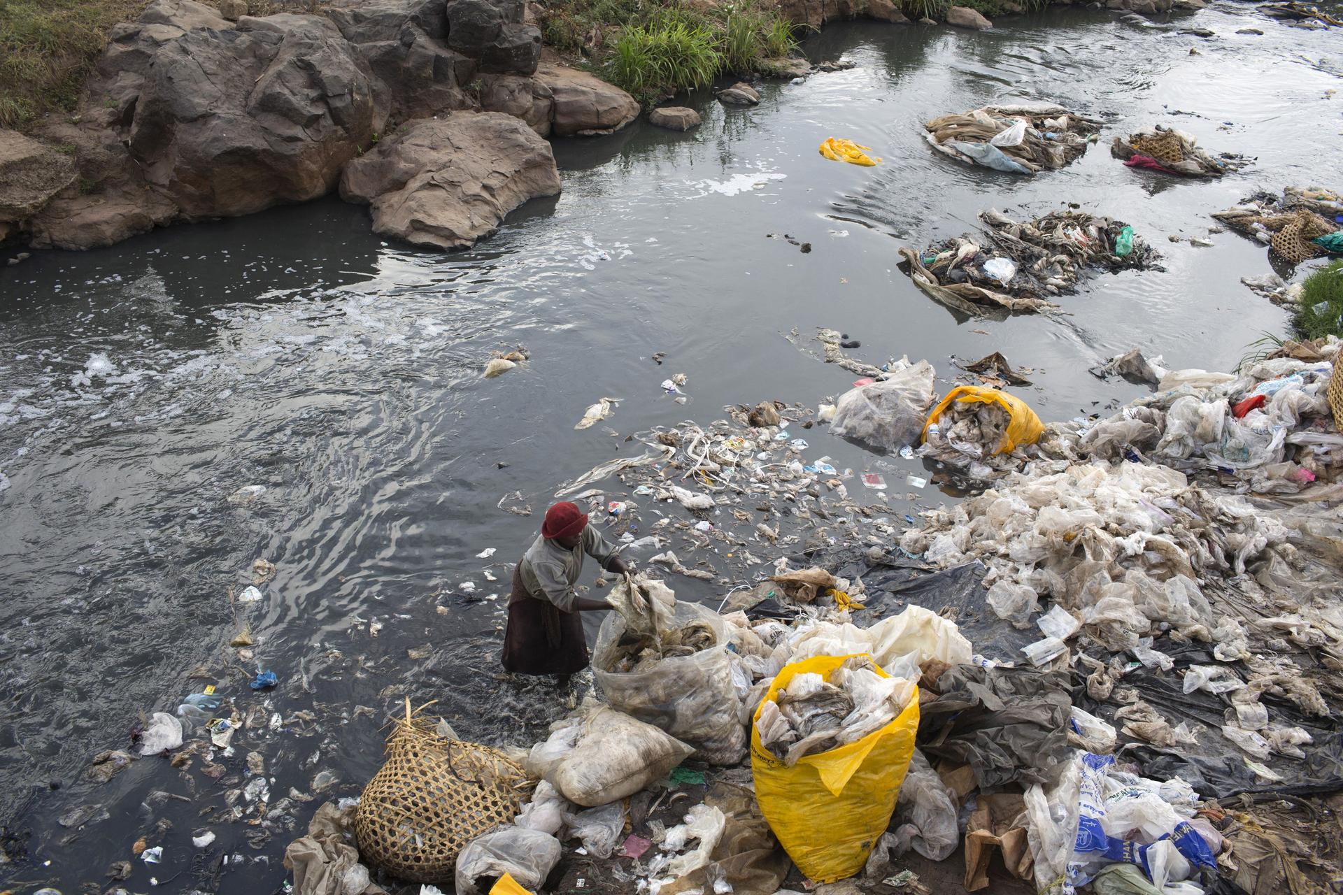 A woman recycles plastic bags from a river near the Dondora dumpsite close to the slum of Korogocho in the capital Nairobi, Kenya, March 17, 2015