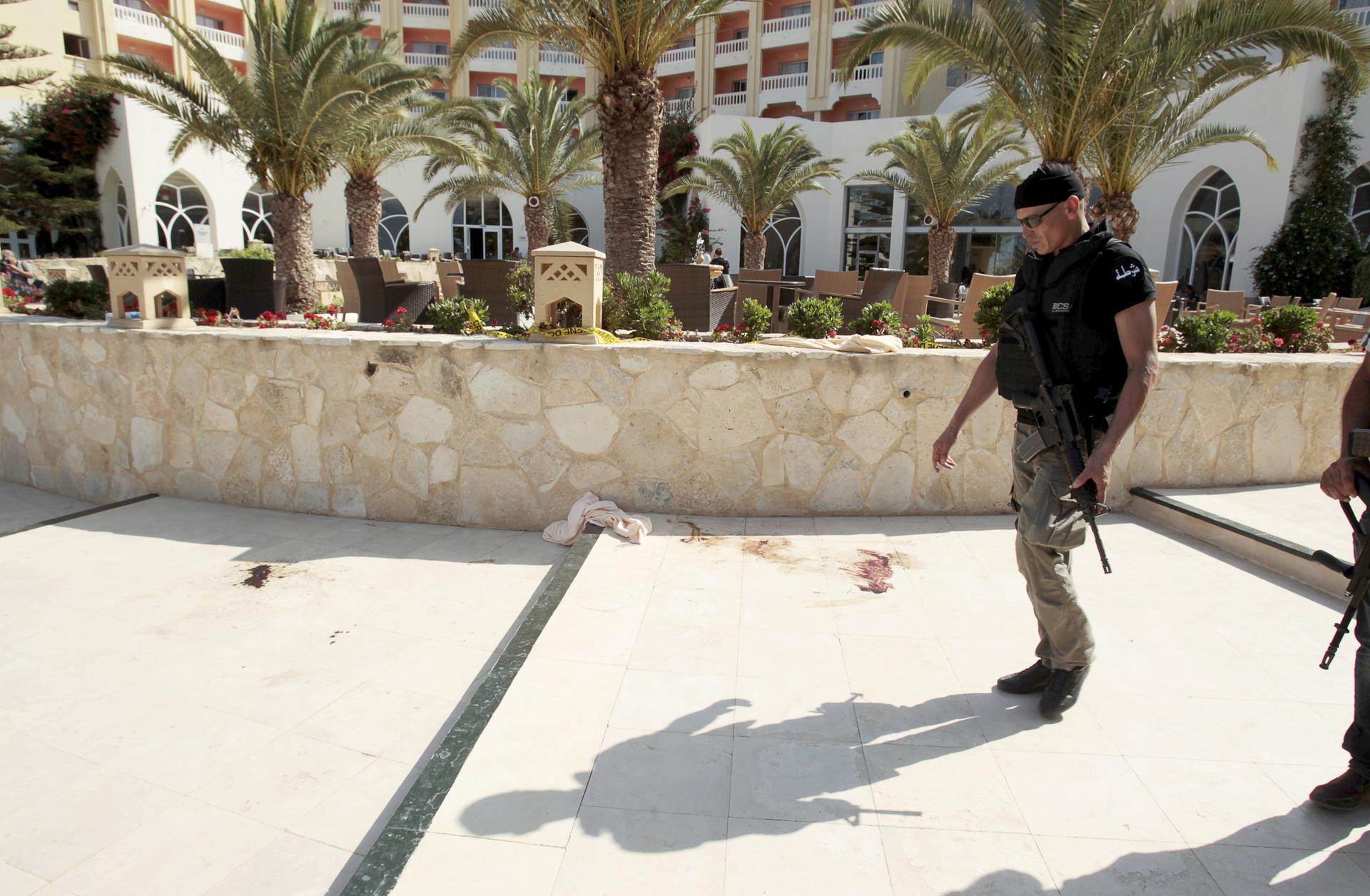 A police officer walks past blood at the Imperiale Marhaba hotel after a gunman opened fire at the beachside hotel in Sousse, Tunisia.
