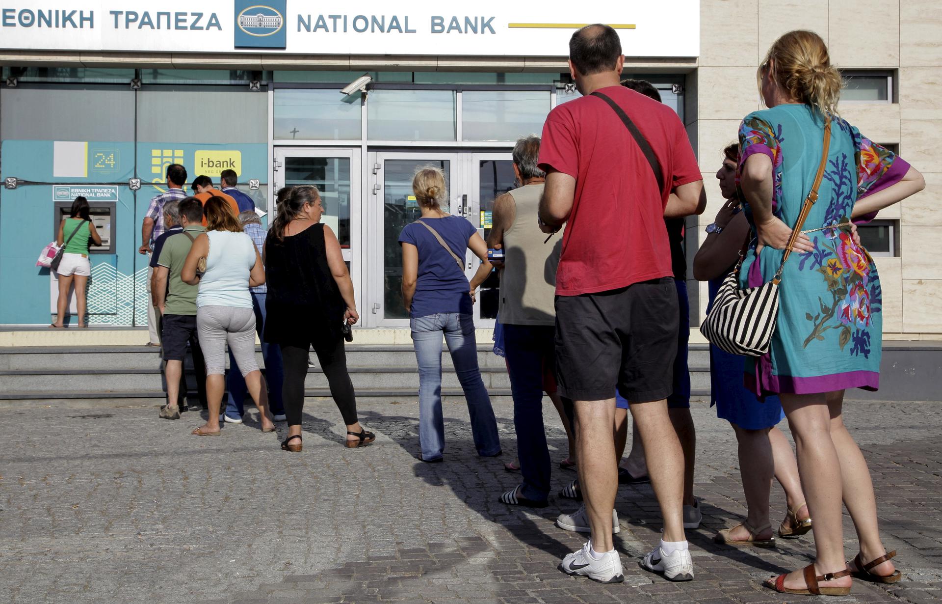 People line up to withdraw cash from an ATM in Greece