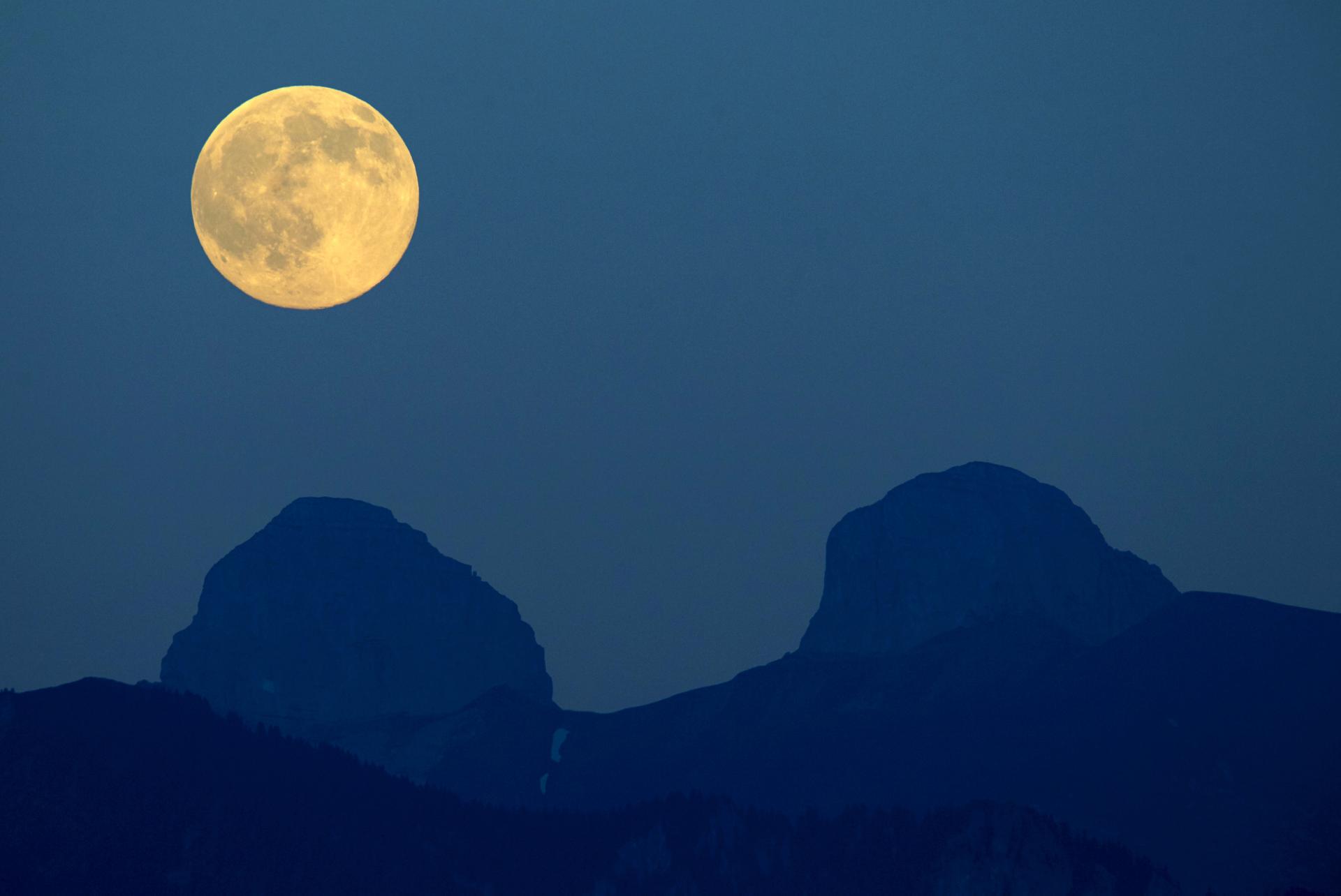 The full moon rises over the Swiss Alps