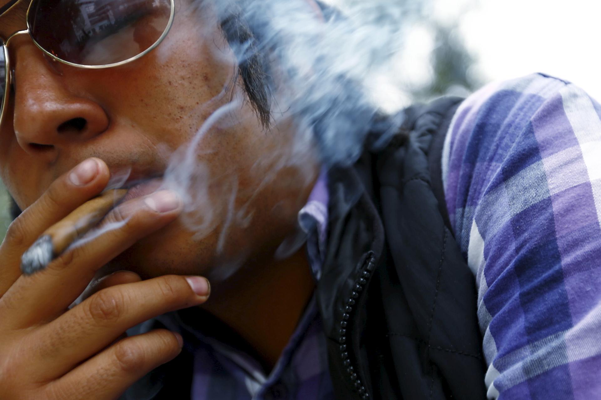 A man smokes during a rally to inform citizenship about marijuana use outside the Senate building in Mexico City, Mexico, July 7, 2015.