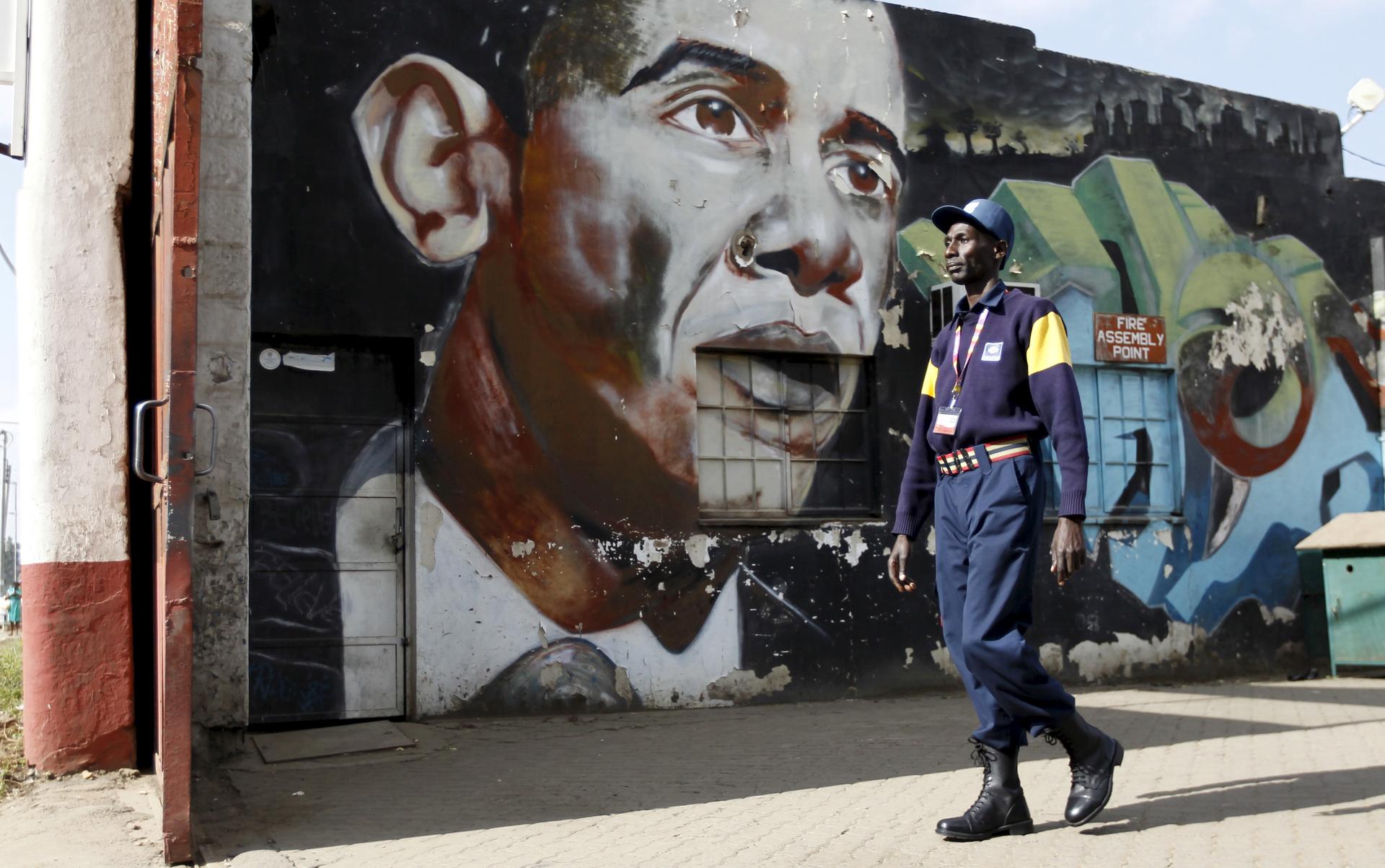 A security guard walks past a wall mural depicting President Barack Obama in Kenya's capital, Nairobi