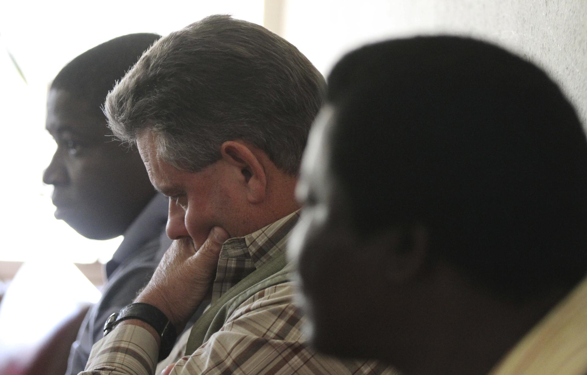 Zimbabwean hunter Theo Bronkhorst (center) waits to appear in Hwange magistrates court. Bronkhorst is one of the two Zimbabwean men who were paid $50,000 by an American hunter who killed "Cecil," the country's best-known lion.