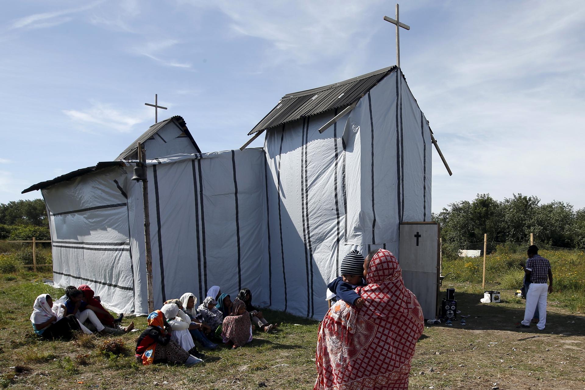 Christian women from Ethiopia and Eritrea sing during the Sunday mass at the church in the migrants' camp near Calais, France