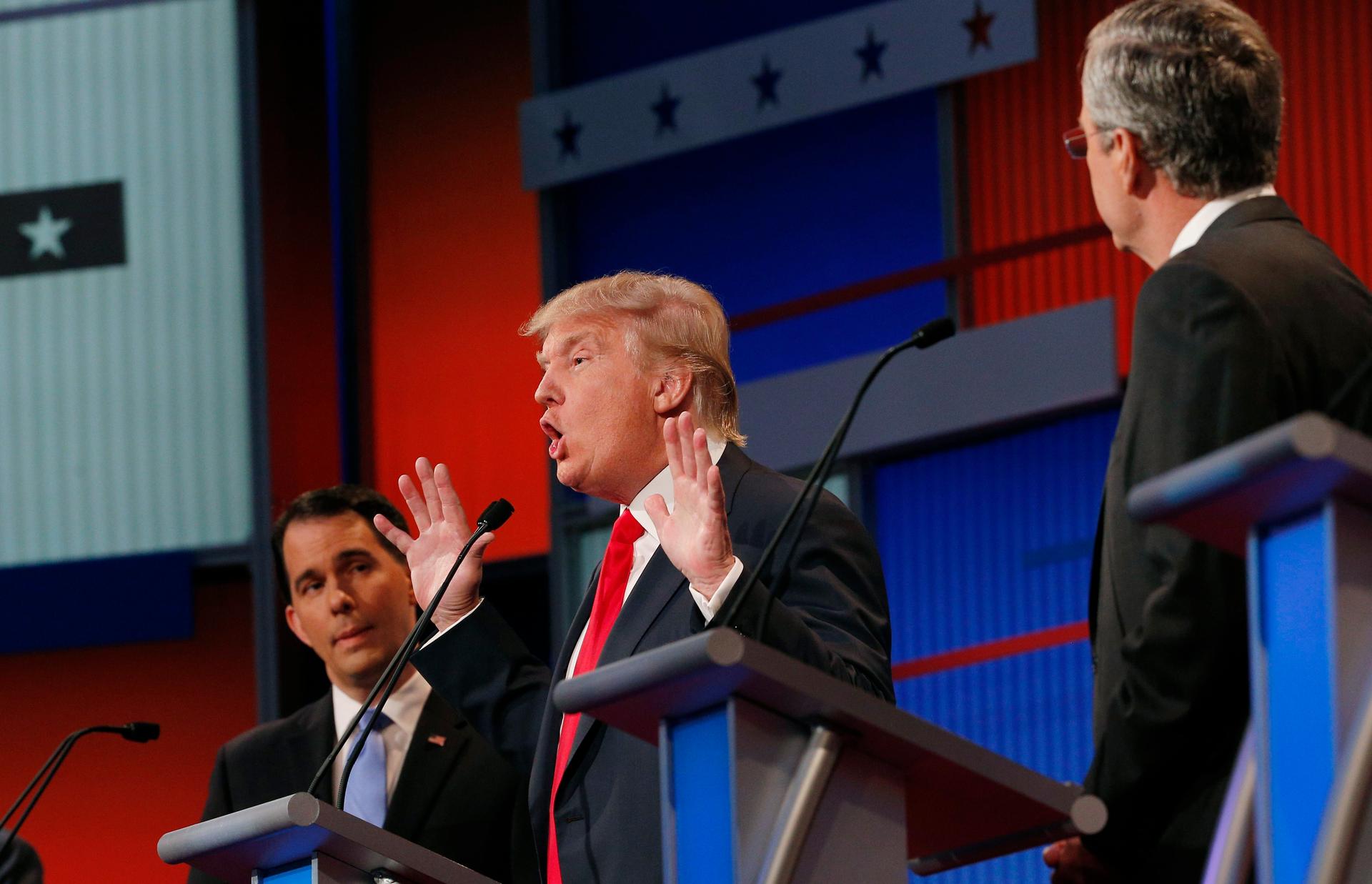 Donald Trump (C) center stage as fellow candidates Scott Walker (L) and Jeb Bush (R) listen at the first official debate in Cleveland, Ohio, August 6, 2015.