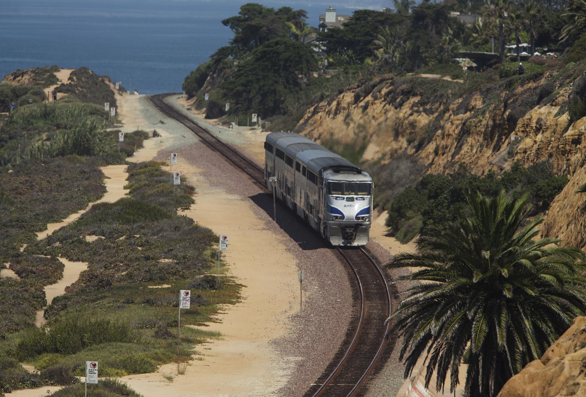 An Amtrak passenger train makes its way along the coastline