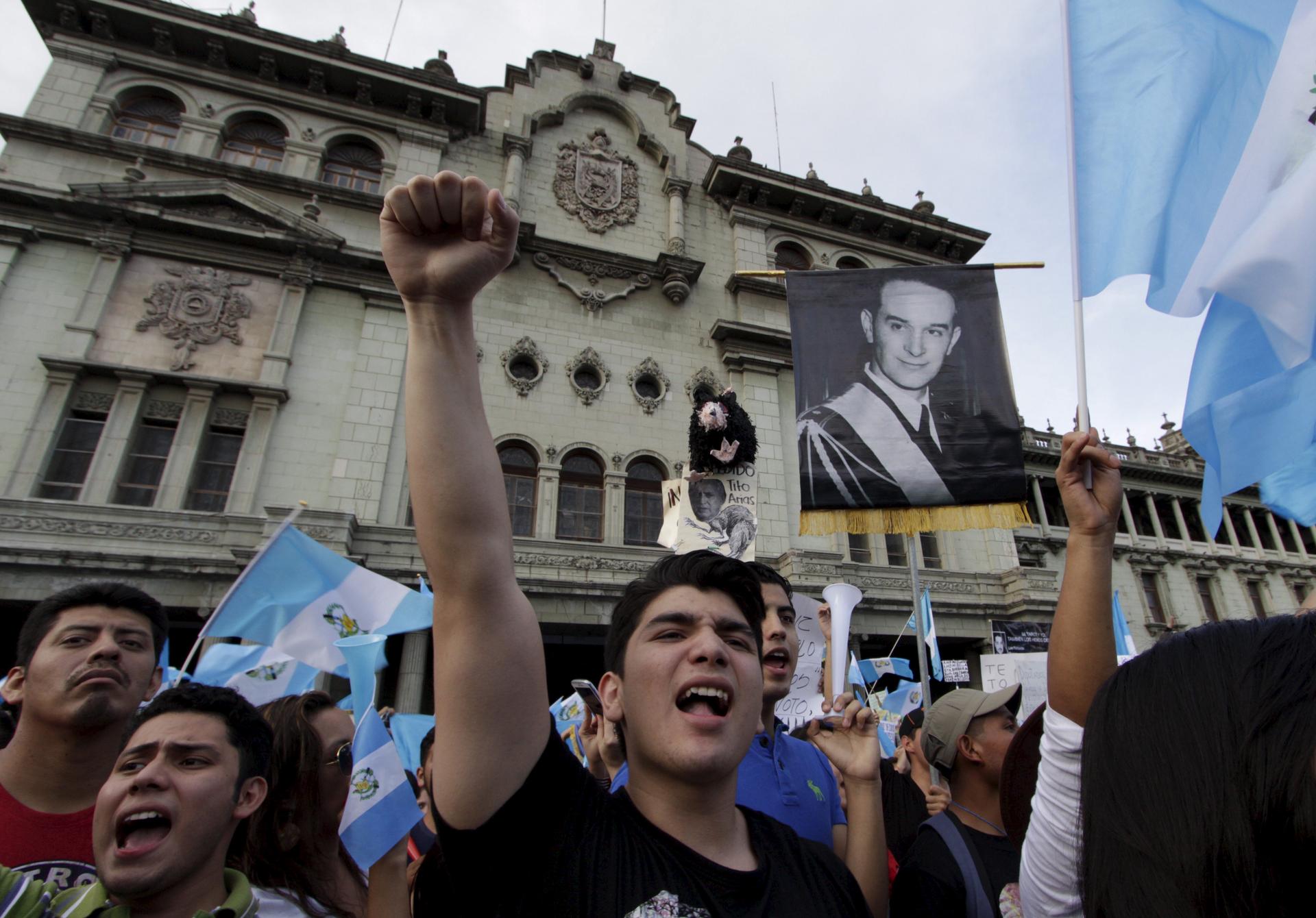 Demonstrators shout as they hold Guatemalan national flags and a picture of former Guatemalan President Jacobo Arbenz, during a protest against Guatemala's President Otto Perez in Guatemala City, Guatemala, August 22, 2015.