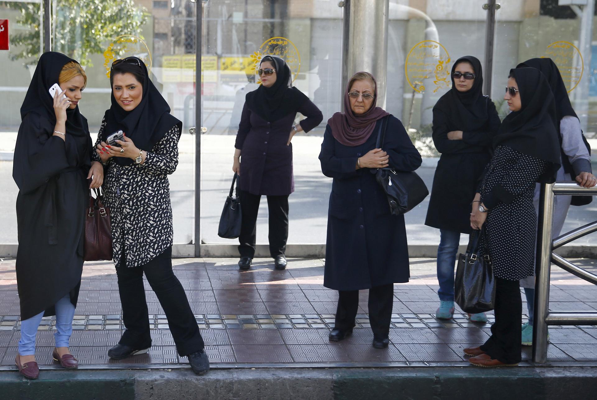 Women wait for a bus in central Tehran, Iran August 24, 2015.