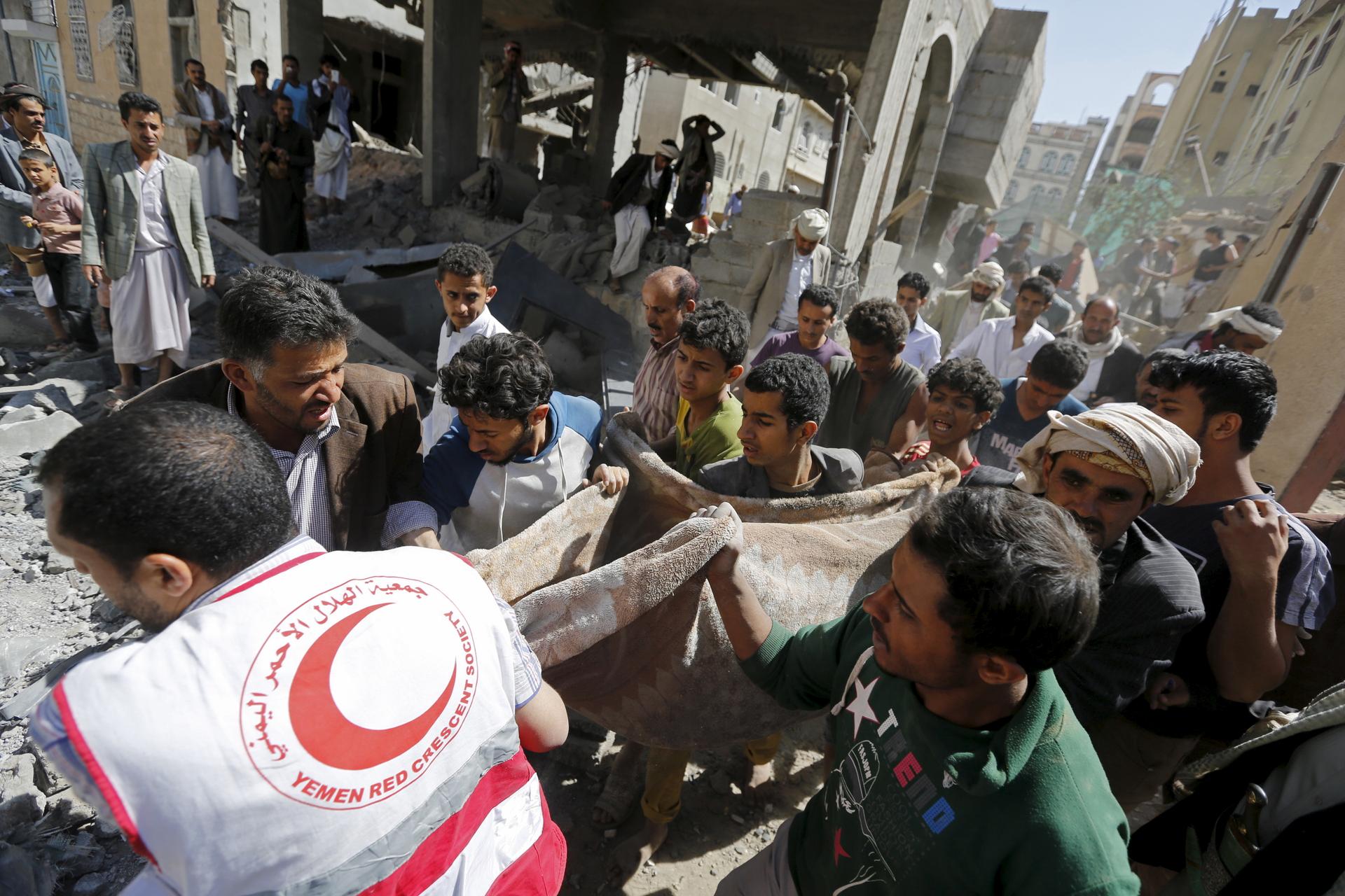 A medic and people carry the body of a boy following a Saudi-led air strike in Yemen's capital Sanaa September 22, 2015.
