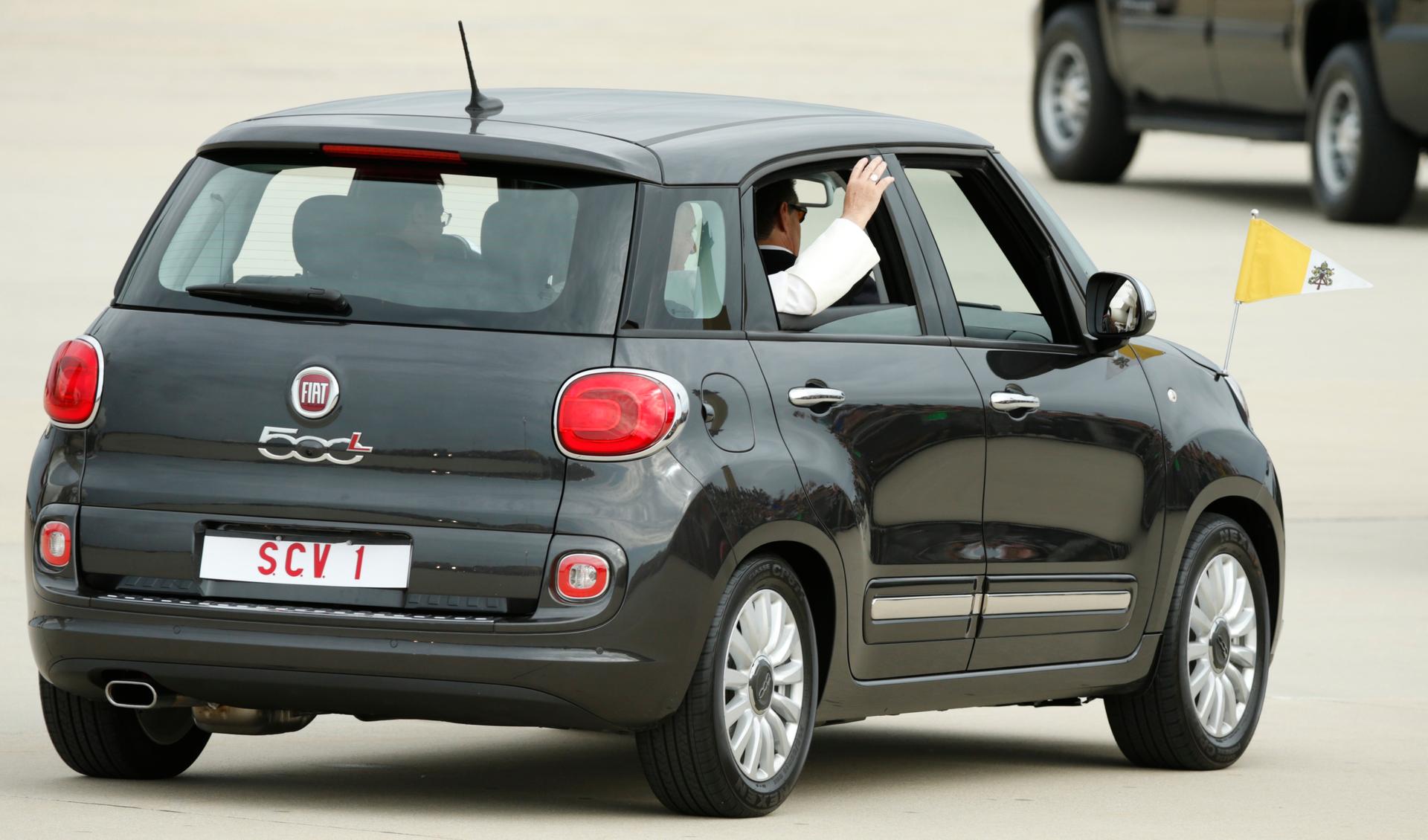 Pope Francis waves as he departs Joint Base Andrews, Maryland, in a Fiat 500 after arriving for his first trip to the United States. 