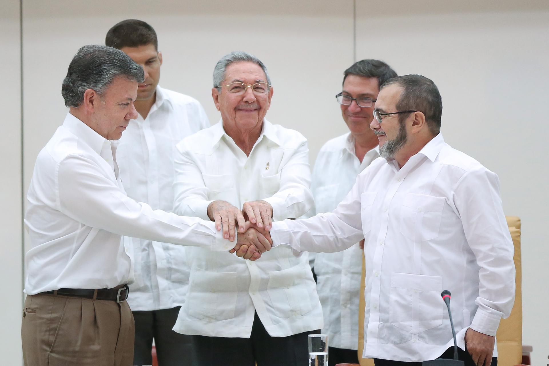 Cuba's President Raul Castro oversees a handshake between Colombia's President Juan Manuel Santos (left) and FARC rebel leader Rodrigo Londono (right), better known by the nom de guerre Timochenko. 