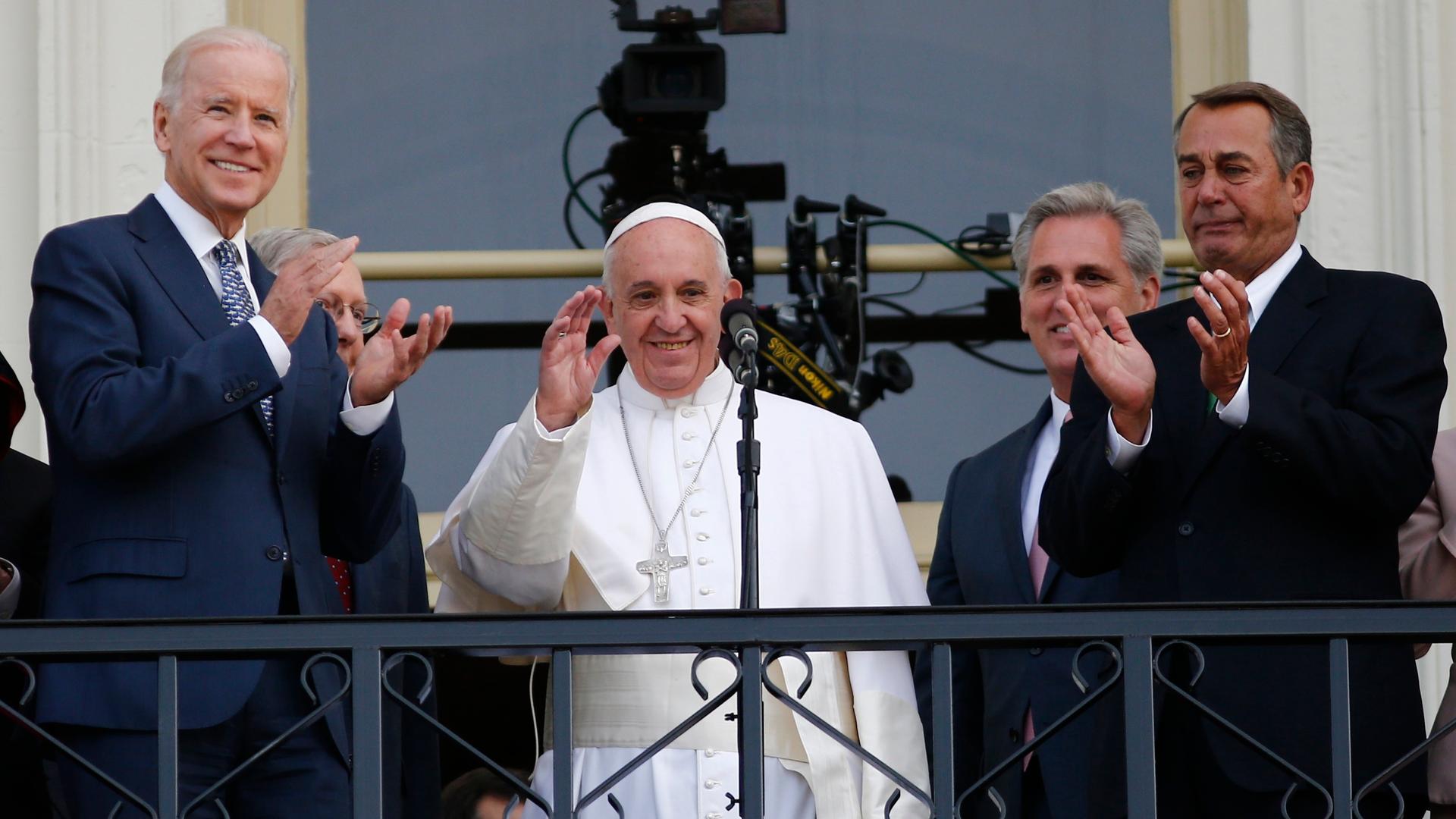 Pope Francis waves to the crowd from the Speaker's Balcony on the West Front of the Capitol as he stands with Vice President Joe Biden (L) and Speaker of the House John Boehner (R) after concluding his address before a joint meeting of the U.S. Congress o