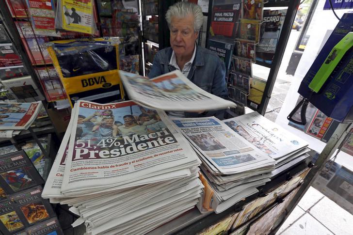 A man sells newspapers printed with the frontpage image of Argentina's president-elect Mauricio Macri in Buenos Aires.