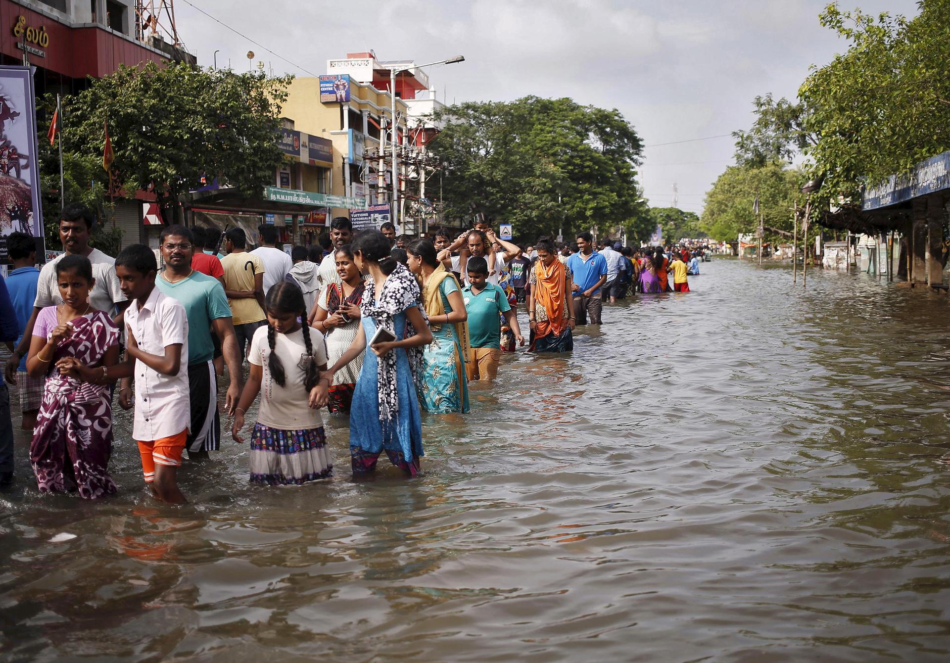 Residents wade through a flooded street as they evacuate their homes in Chennai, in the southern state of Tamil Nadu, India, December 3, 2015.