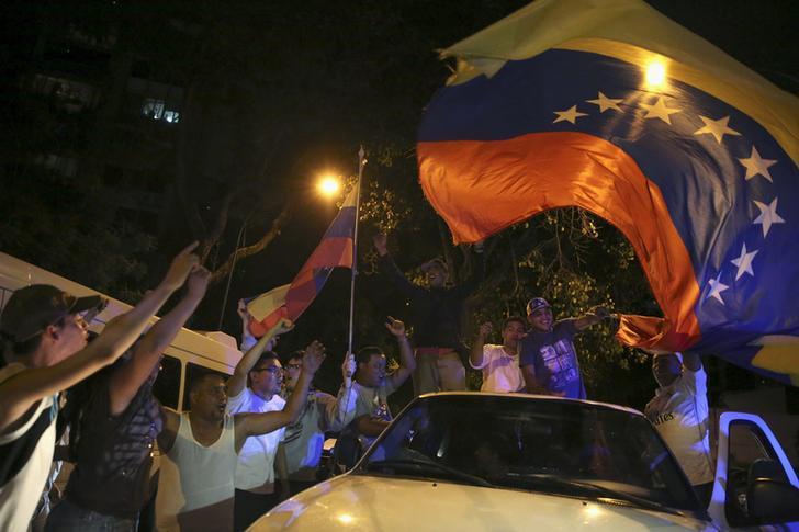 ​Supporters of the opposition Democratic Unity coalition wave a Venezuelan national flag from a car while they celebrate their victory on a street in Caracas December 7, 2015.