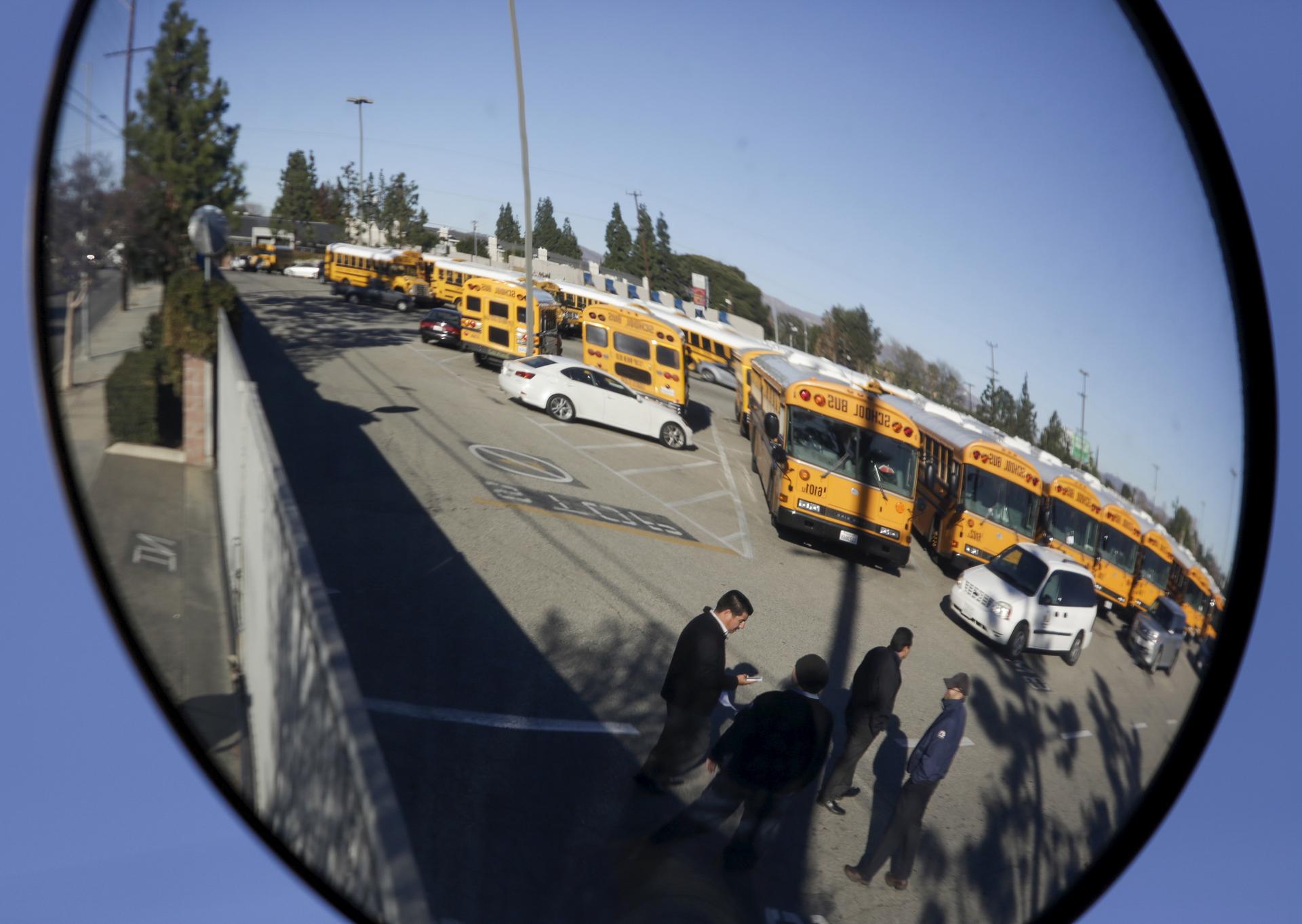 A Los Angeles Unified School District (LAUSD) school bus yard is reflected in a mirror in the North Hills neighborhood of Los Angeles,