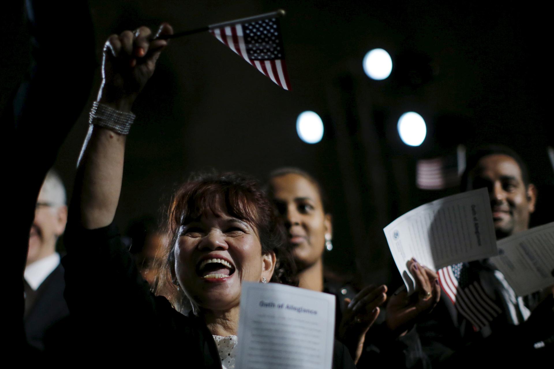 People celebrate as they become U.S. citizens during a naturalization ceremony at the National Archives Museum in Washington.