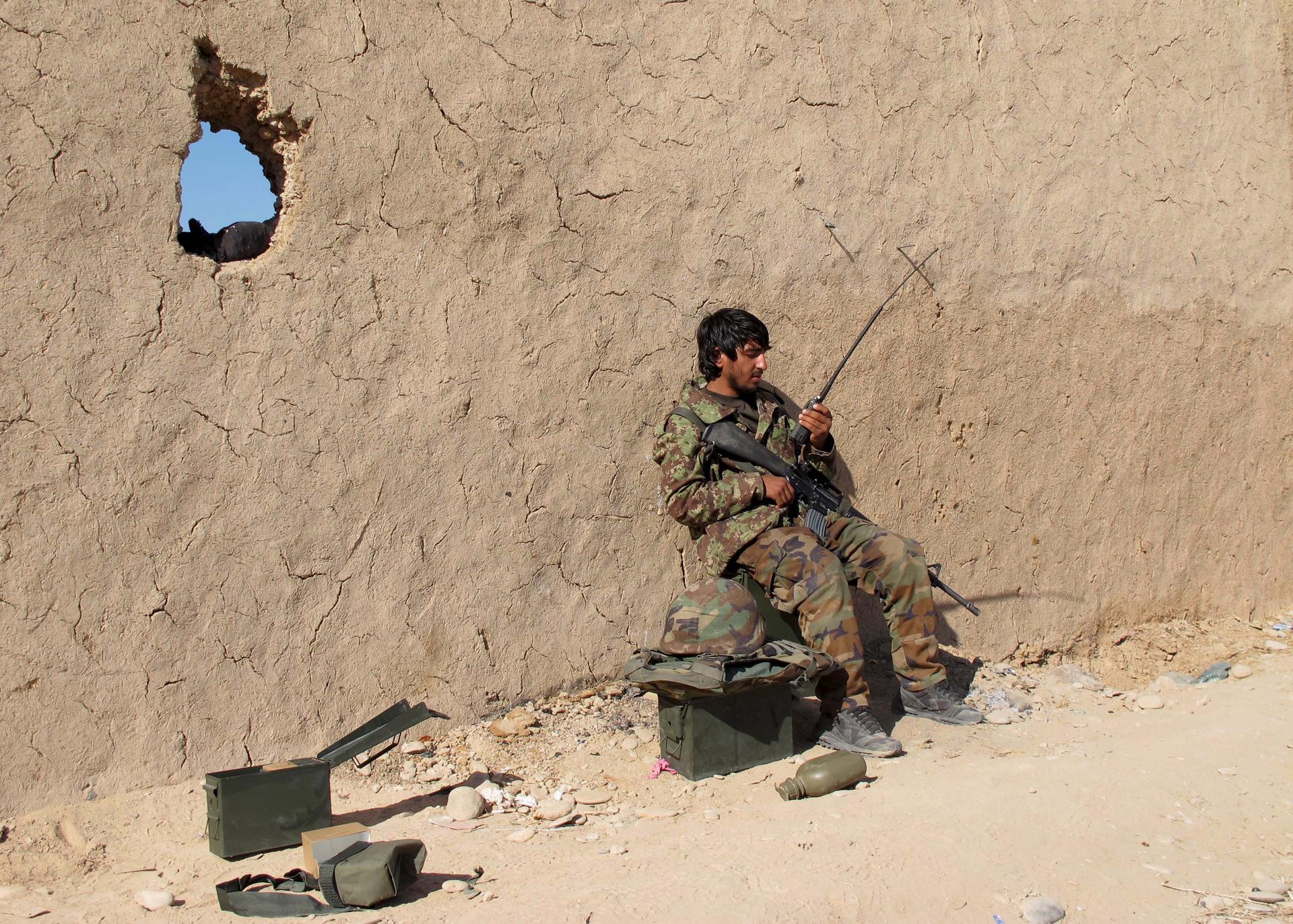 An Afghan National Army (ANA) soldier speaks on a radio at an outpost in Helmand province, December 20, 2015.