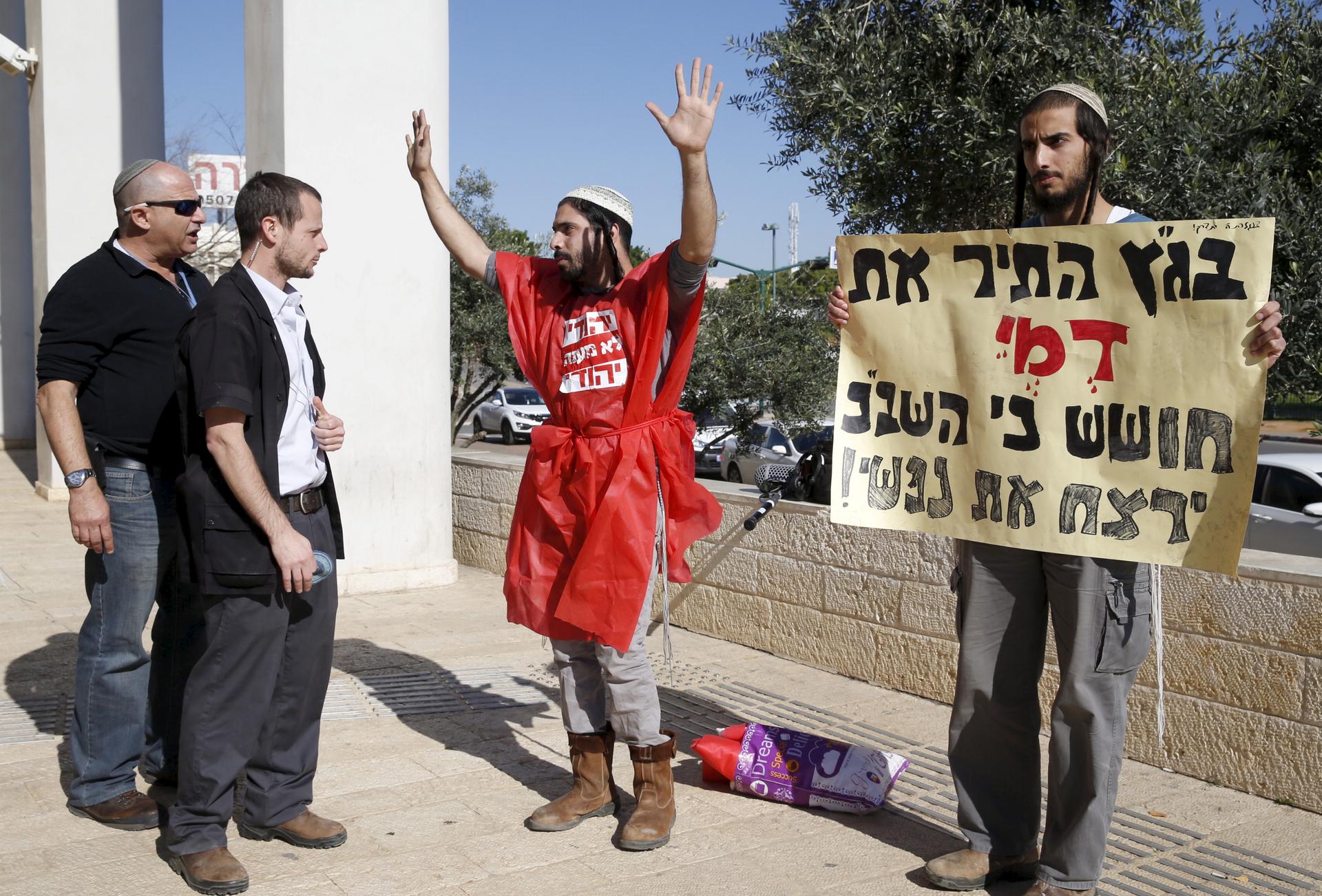 Israeli ultranationalists (right) protest against alleged interrogation methods used by Israel's domestic security service Shin Bet on suspects in a fatal arson attack last July in a Palestinian West Bank village, during a court hearing in the case held o