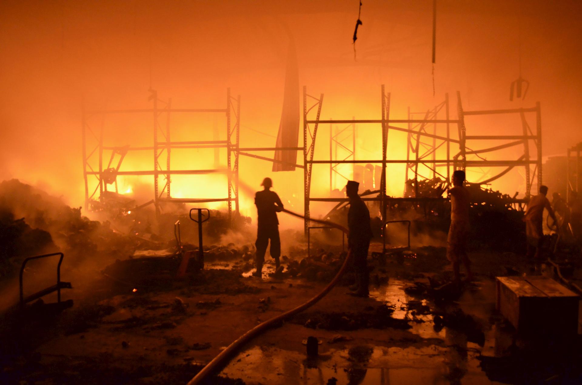 Firefighters attempt to extinguish a fire at a foodstuff storage facility destroyed by a Saudi-led air strike in Yemen's Red Sea port city of Houdieda January 6, 2016.  