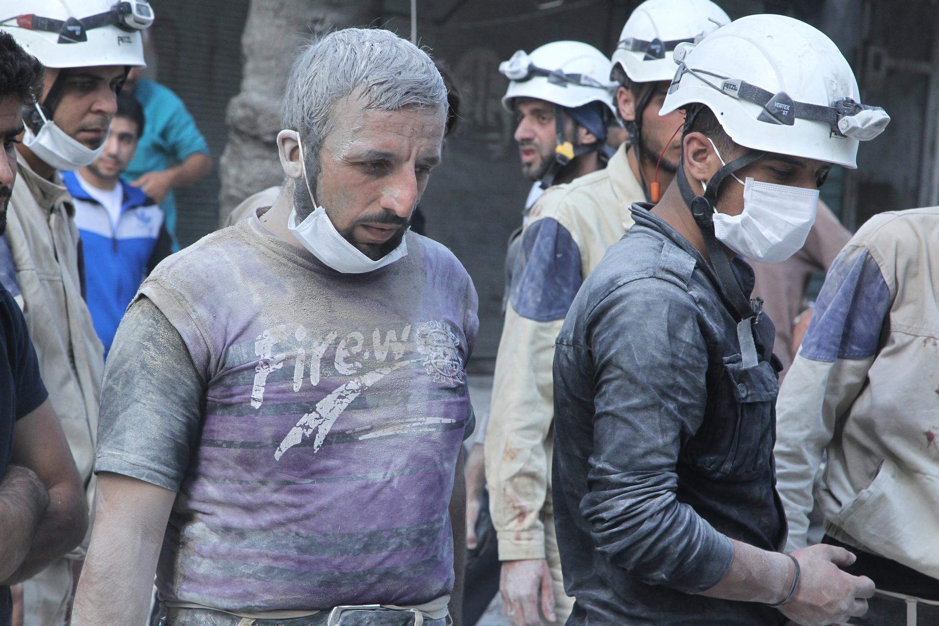 White Helmet volunteers search for survivors at a site reportedly hit with a barrel bomb in the Al-Shaar neighborhood of Aleppo, Syria, on September 17, 2015.