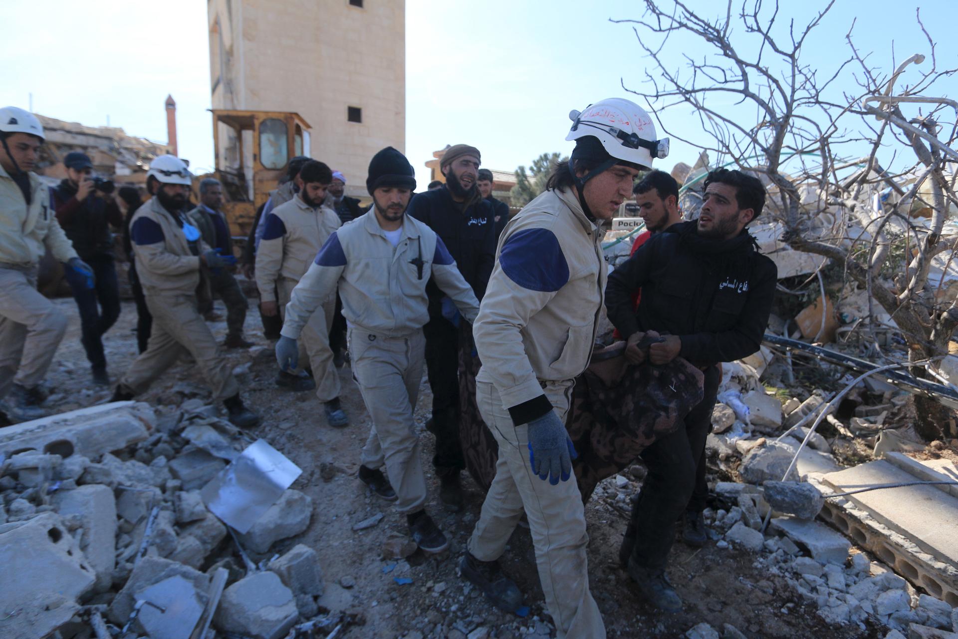 Syrians carry a body from a destroyed Medecins Sans Frontieres (MSF) supported hospital hit by missiles in Marat Numan, Idlib province, Syria.